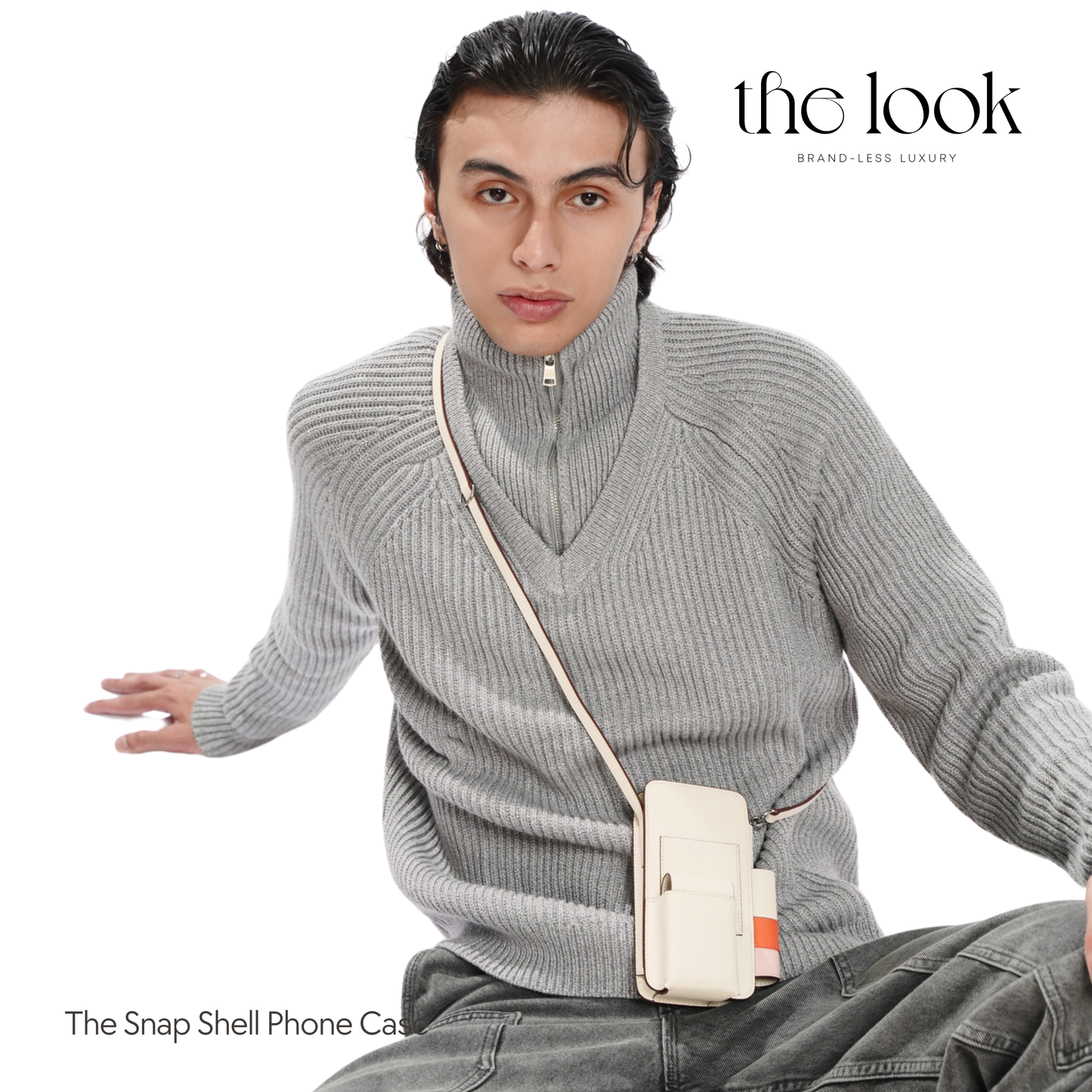 Person wearing a gray sweater with a beige crossbody bag, sitting on a white background with 'the look' branding. | The Look Officiel