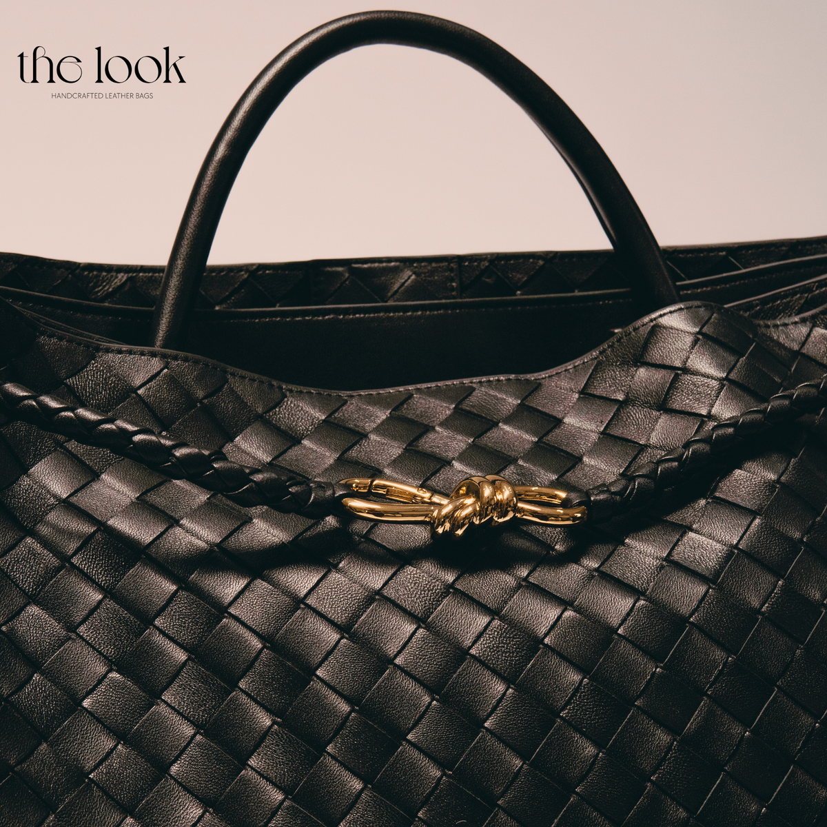 Close-up of The Loop Jumbo Satchel in Black, highlighting the woven lambskin leather and gold hardware.