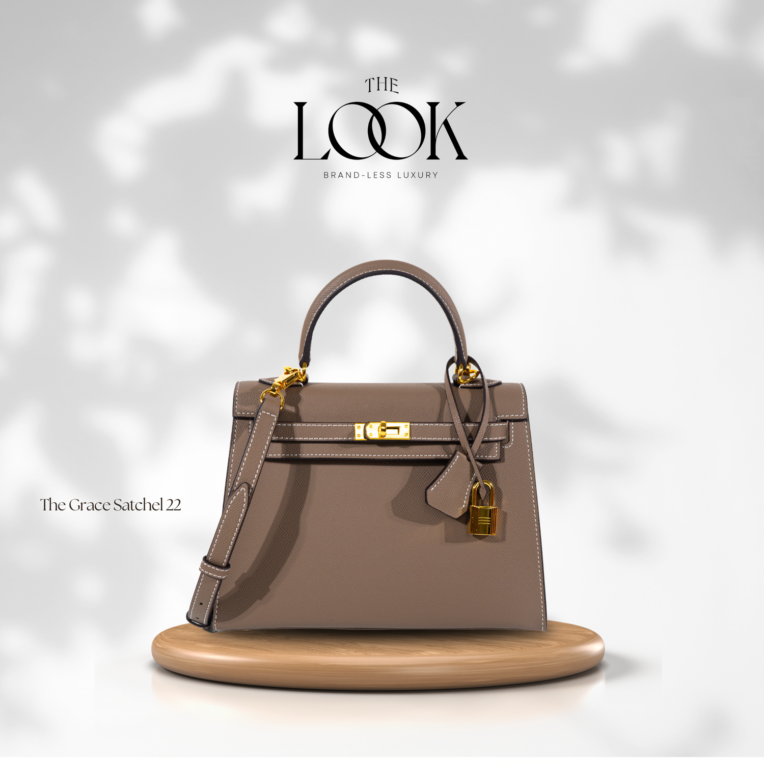 A larger brown leather satchel bag with gold hardware, featuring a top handle with a removable strap and a front flap with a gold lock and key. | The Look Officiel