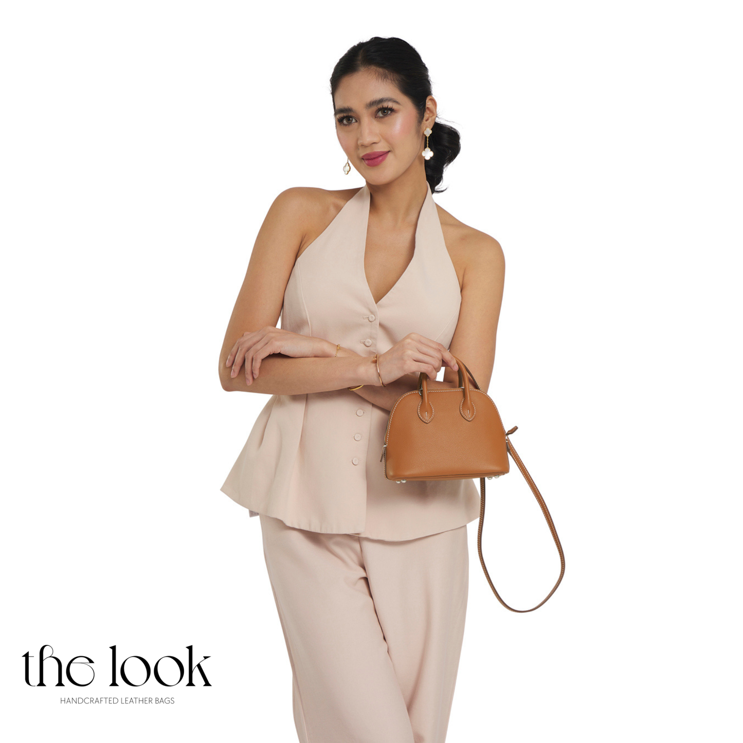 Woman holding a brown handbag (Beaumont Mini)against a white background with 'the look' branding.