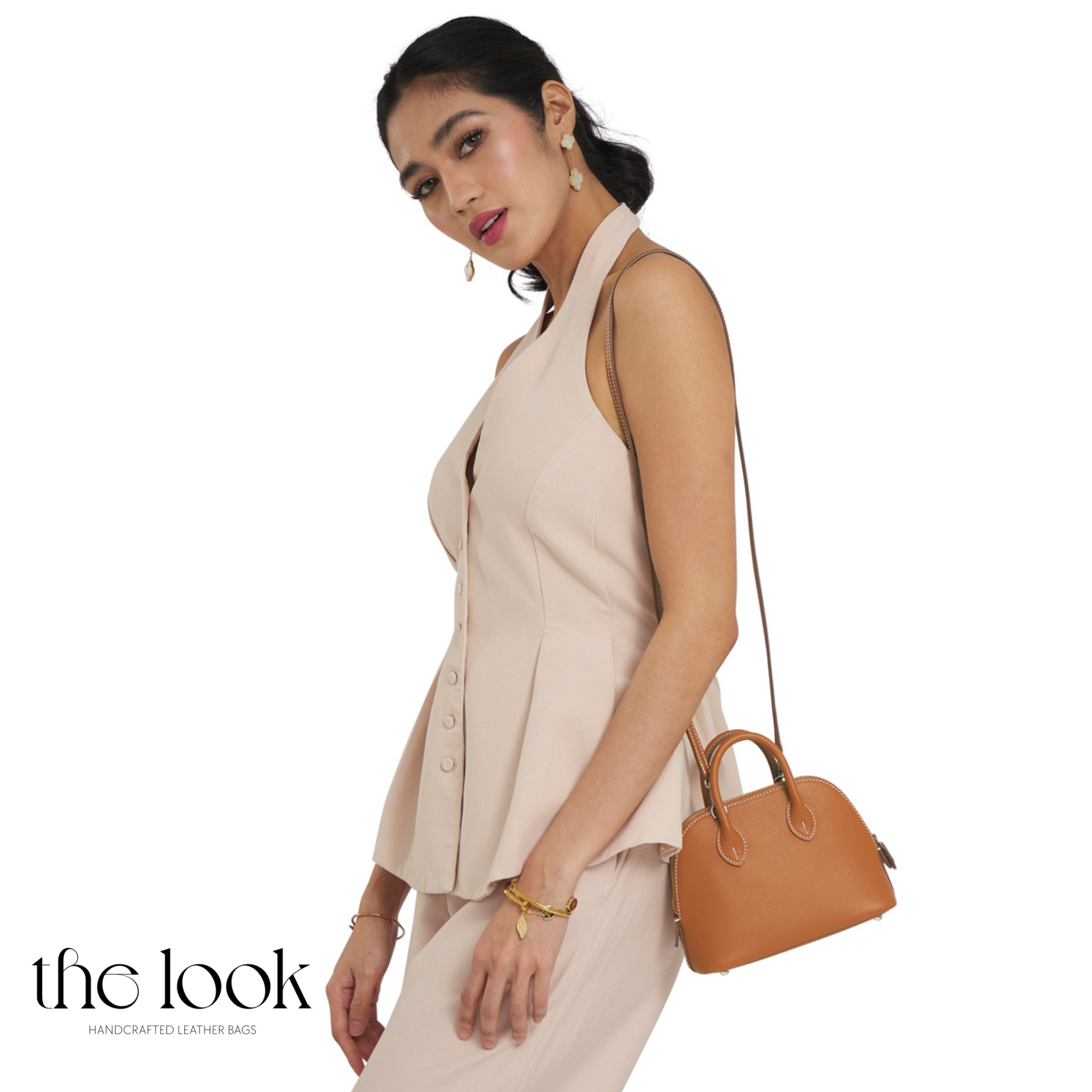 Woman holding a brown handbag against a white background with 'the look' branding.