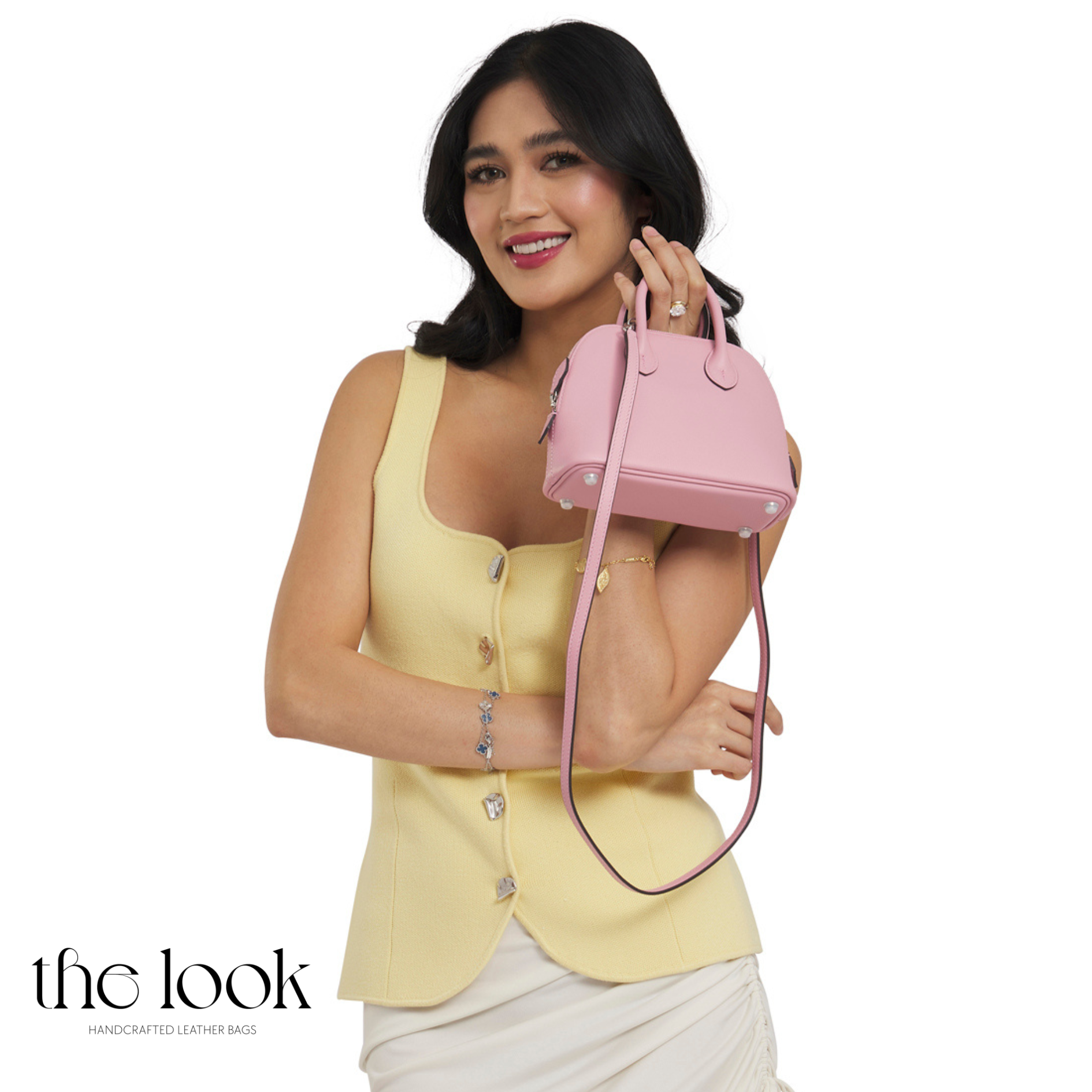 Woman holding a pink handbag against a white background