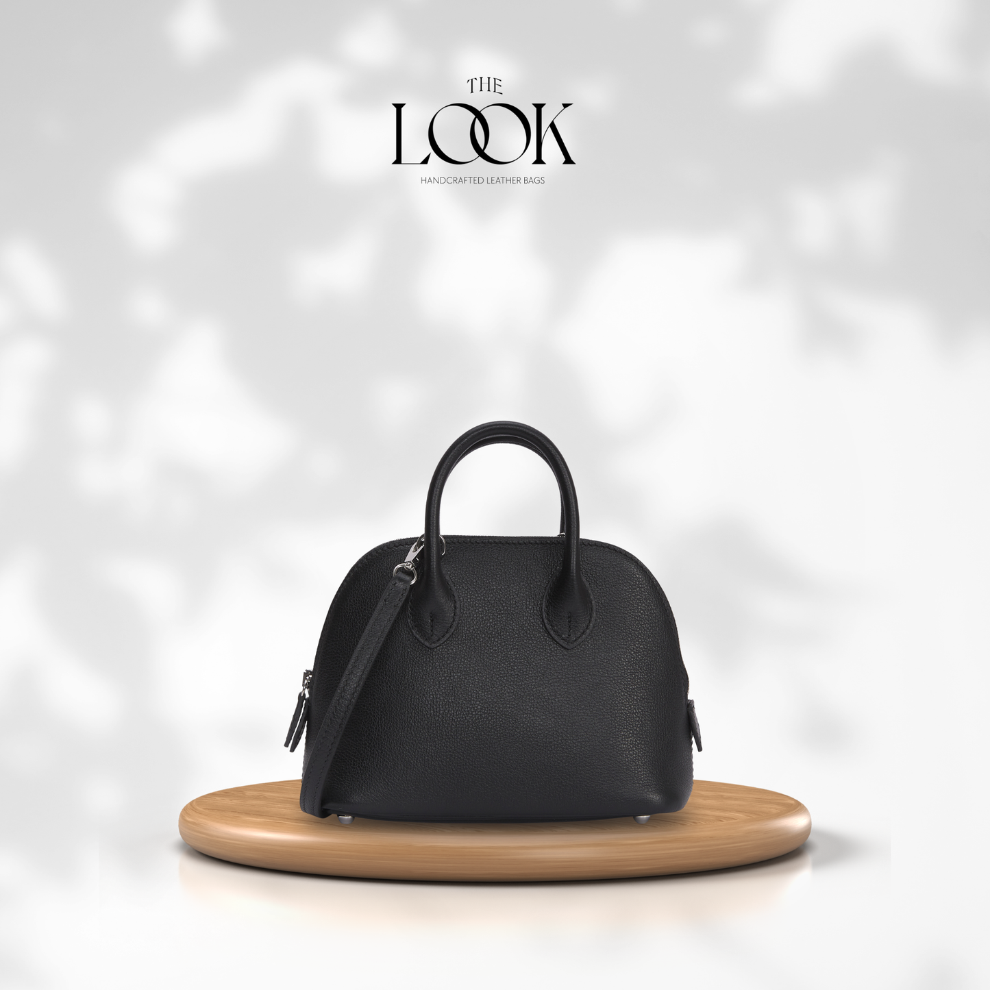 Black handbag on a wooden stand with 'The Look' brand logo in the background| The Look Officiel