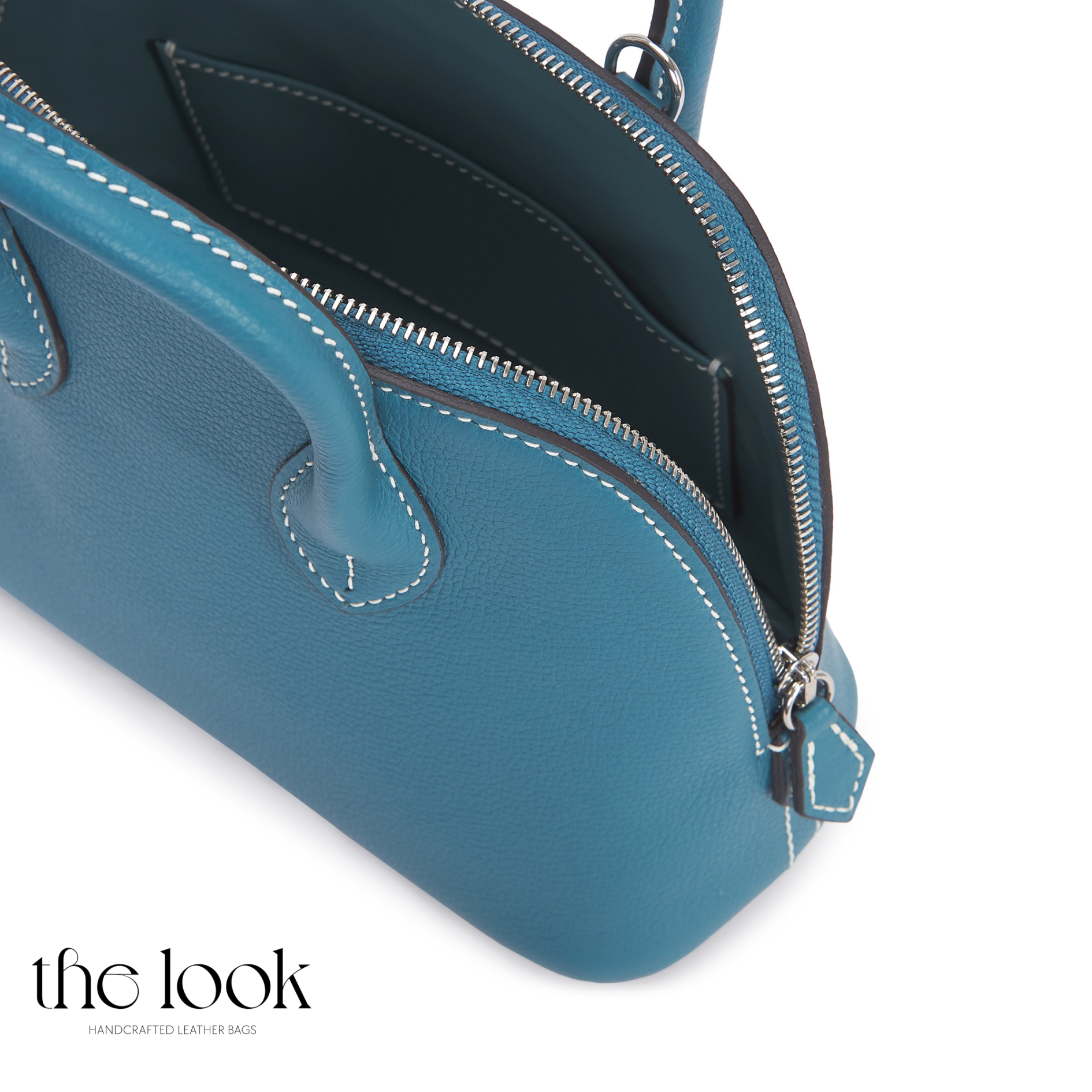 Blue leather handbag with a visible brand logo on a white background | The Look Officiel