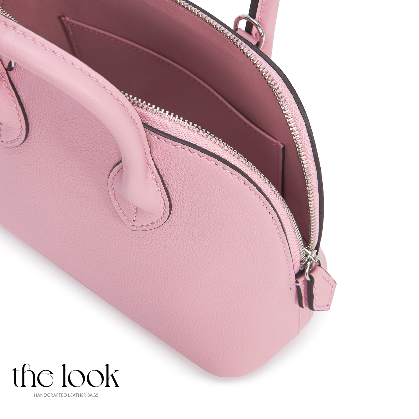 Pink handbag with a visible zipper on a white background, featuring 'the look' brand.| The Look Officiel
