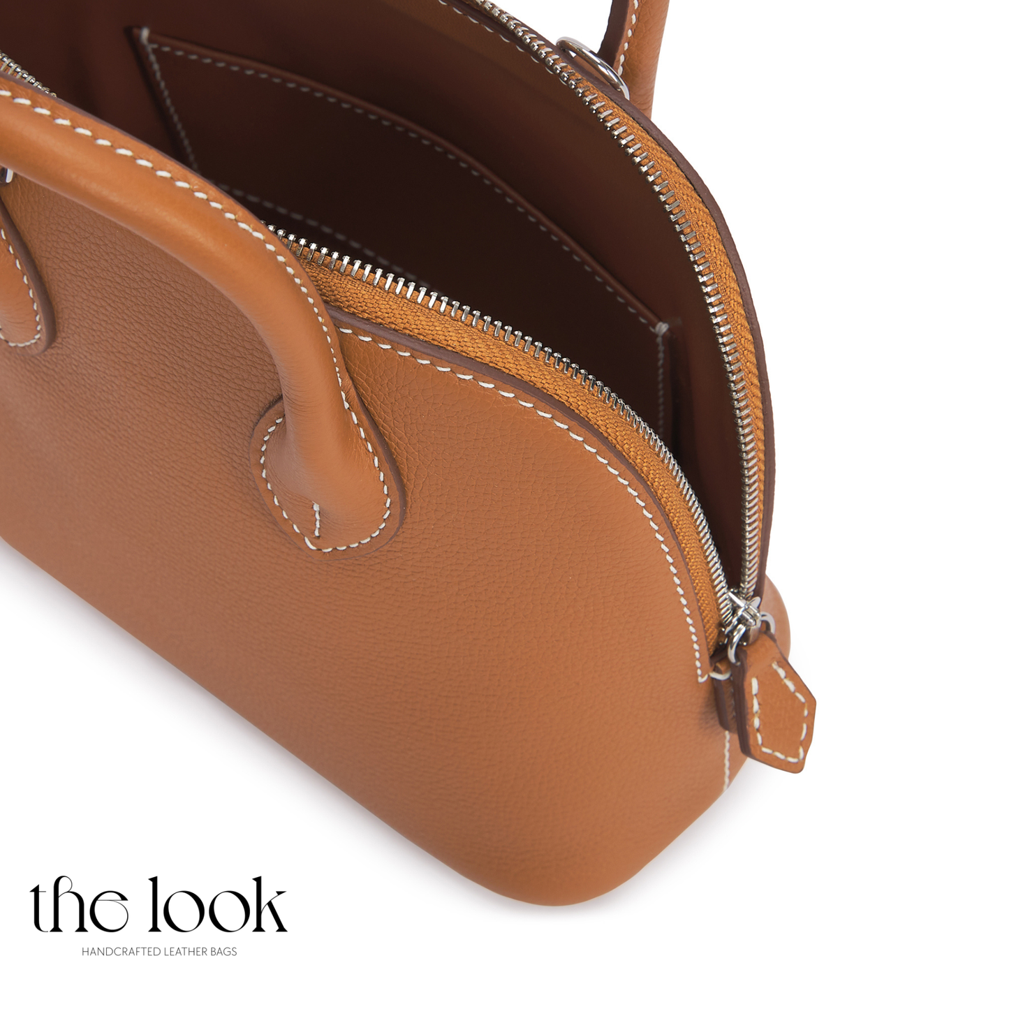 Brown leather handbag with a visible brand logo on a white background | The Look Officiel