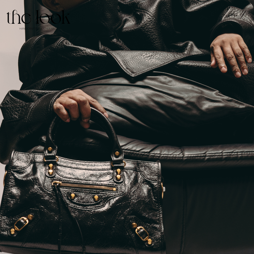Model holding Biker Satchel Medium black goatskin gold brass hardware front view
