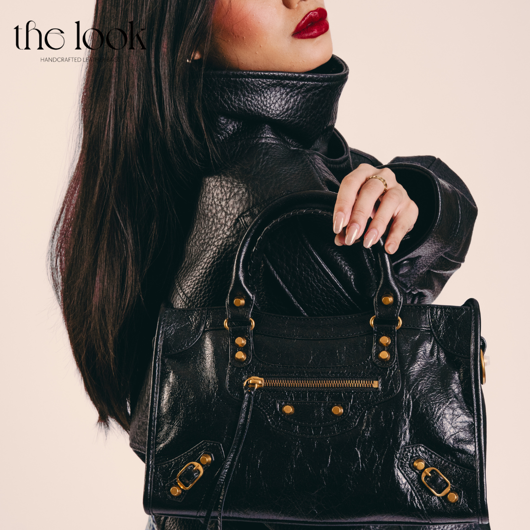 Model holding Biker Satchel Medium black goatskin gold brass hardware front view