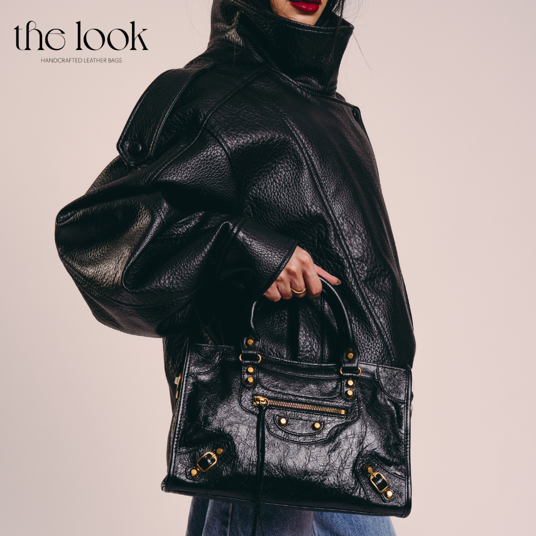 Model holding Biker Satchel Medium black goatskin gold brass hardware front view