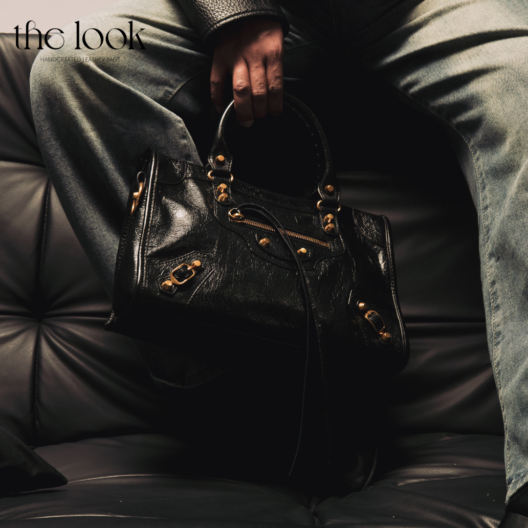 Model holding Biker Satchel Medium black goatskin gold brass hardware front view