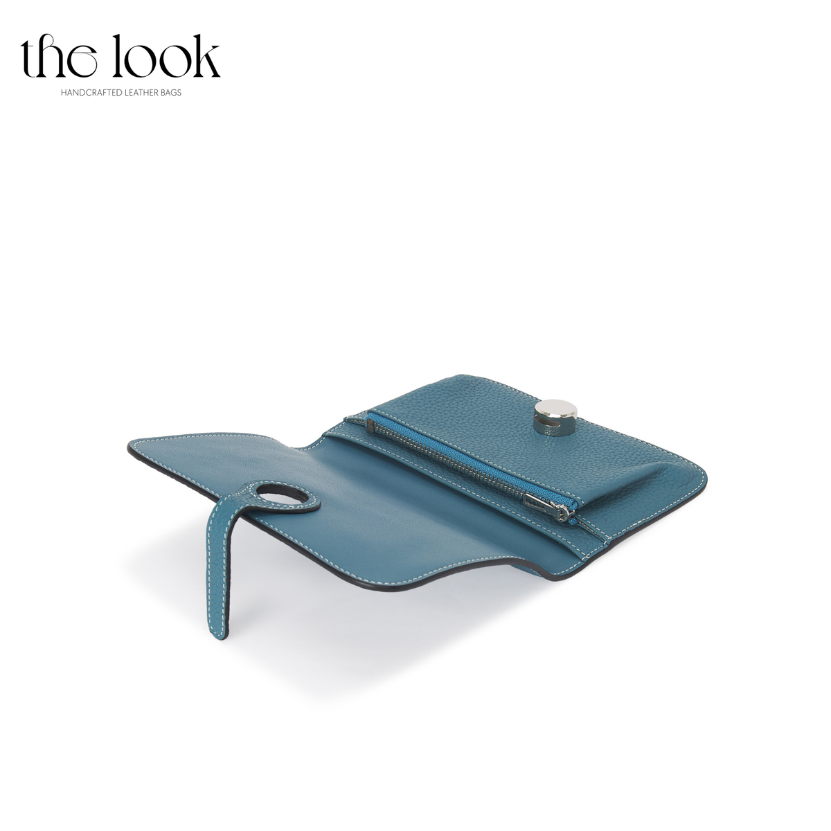 Cleo Small Wallet in Denim Blue top-grain pebbled calfskin leather with stainless steel silver hardware, opened at an angle showing interior organization