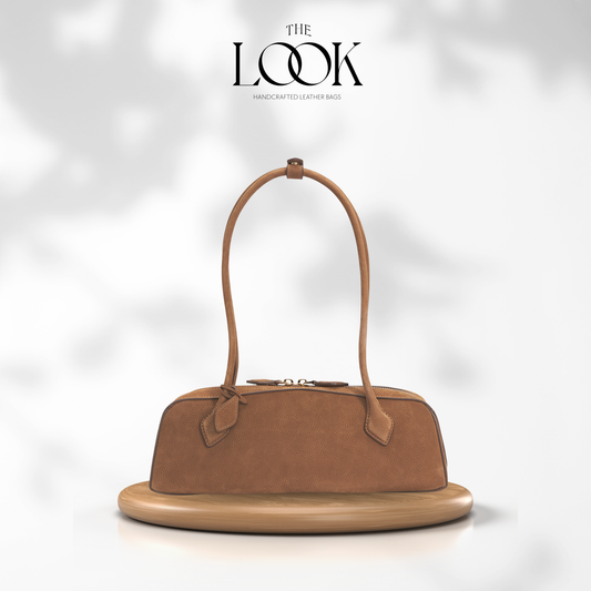 Brown handbag on a white platform with 'The Look' branding. | The Look Officiel