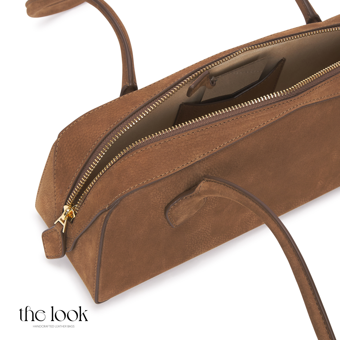 Brown leather handbag with gold zipper on a white background | The Look Officiel