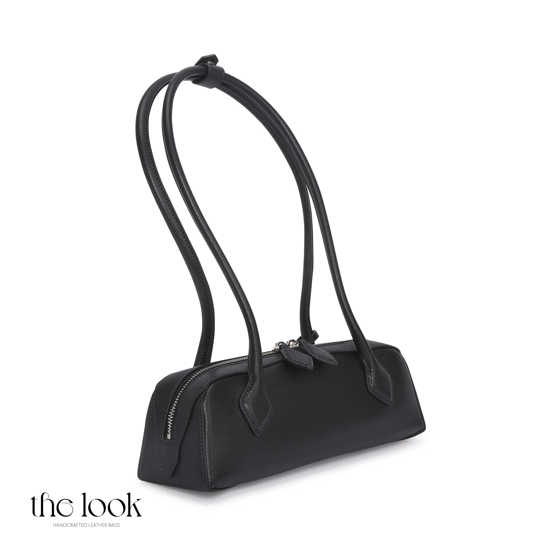 Black handbag with thin shoulder straps on a white background | The Look Officiel
