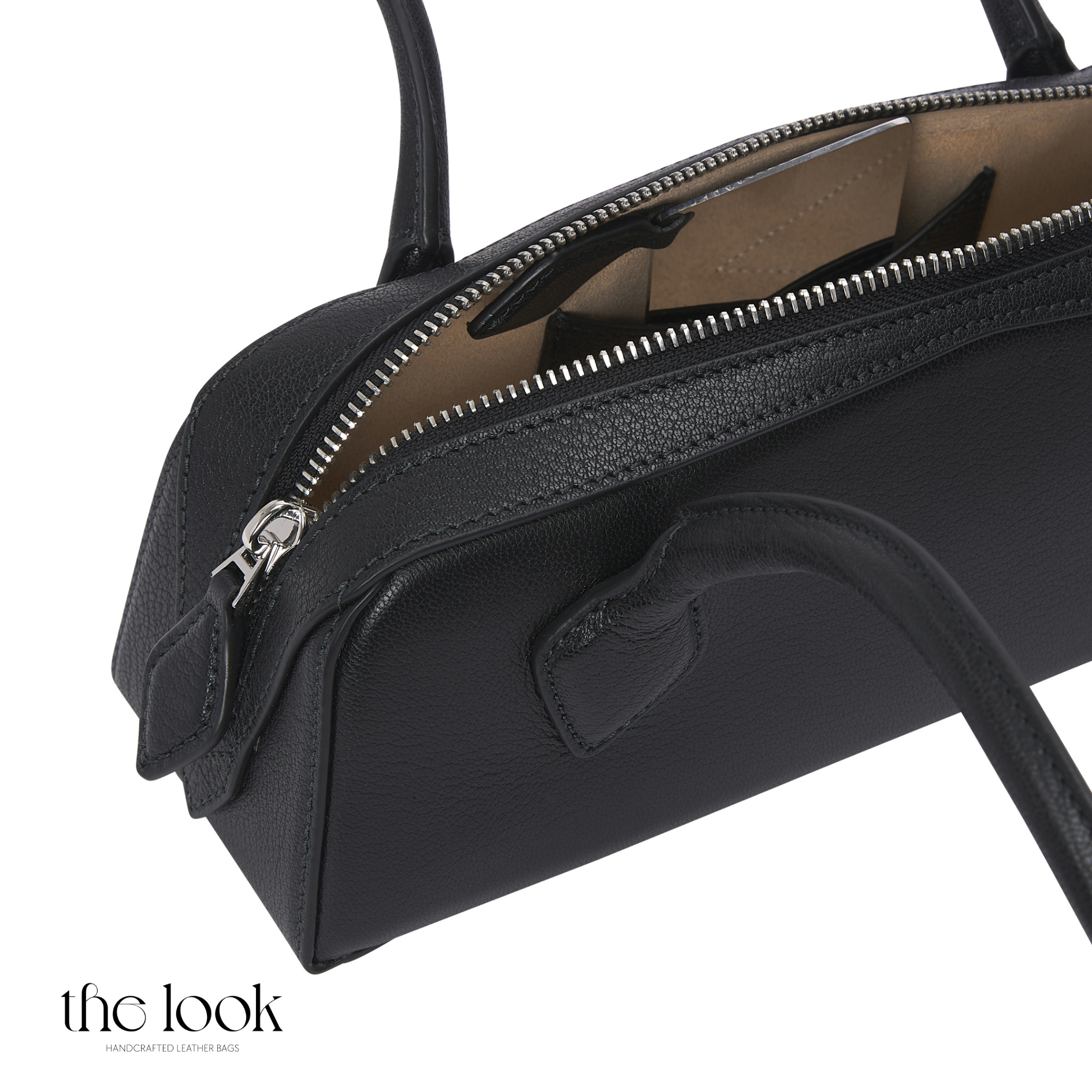 Black handbag with a visible brand logo on a white background | The Look Officiel