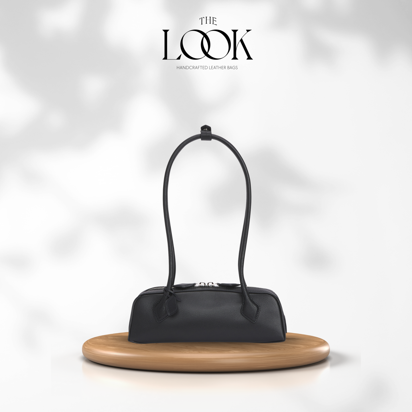 Black handbag on a wooden stand with 'The Look' brand logo in the corner. | The Look Officiel