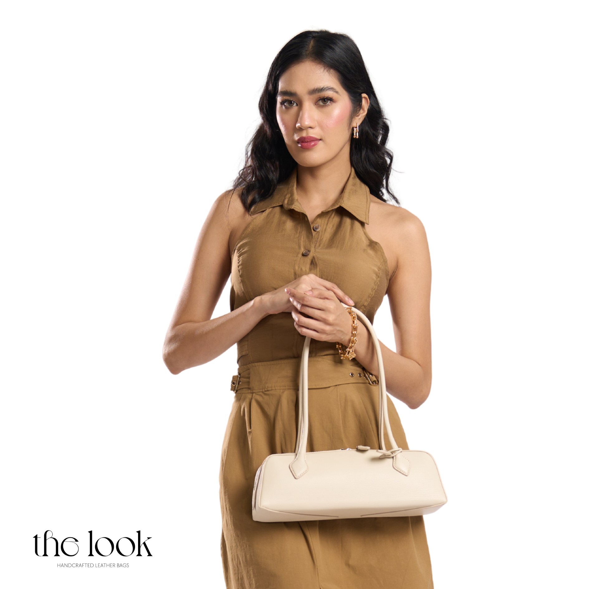 Woman holding a beige handbag against a white background with 'the look' branding. | The Look Officiel