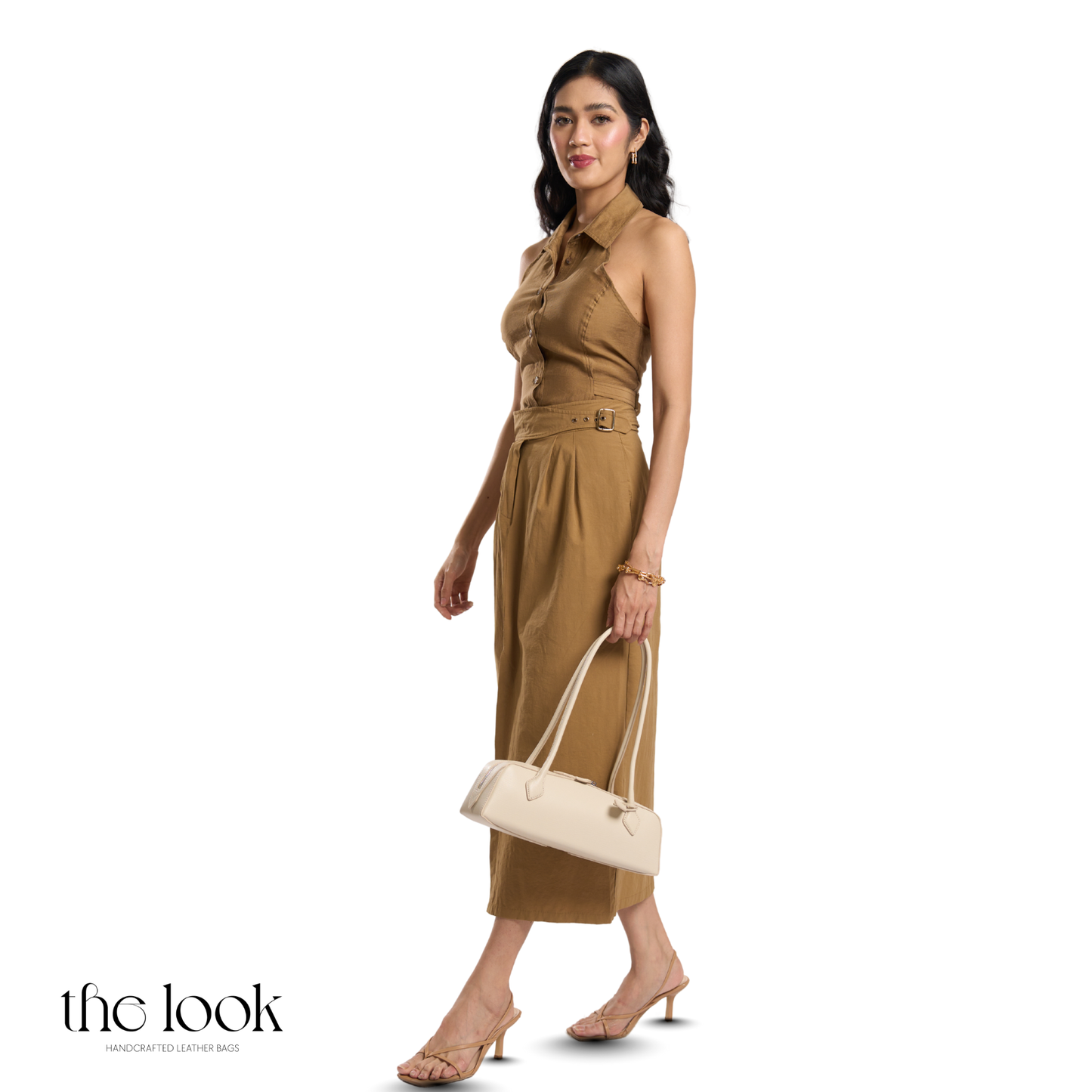 Woman in a brown outfit holding a beige handbag on a white background with 'the look' branding. | The Look Officiel