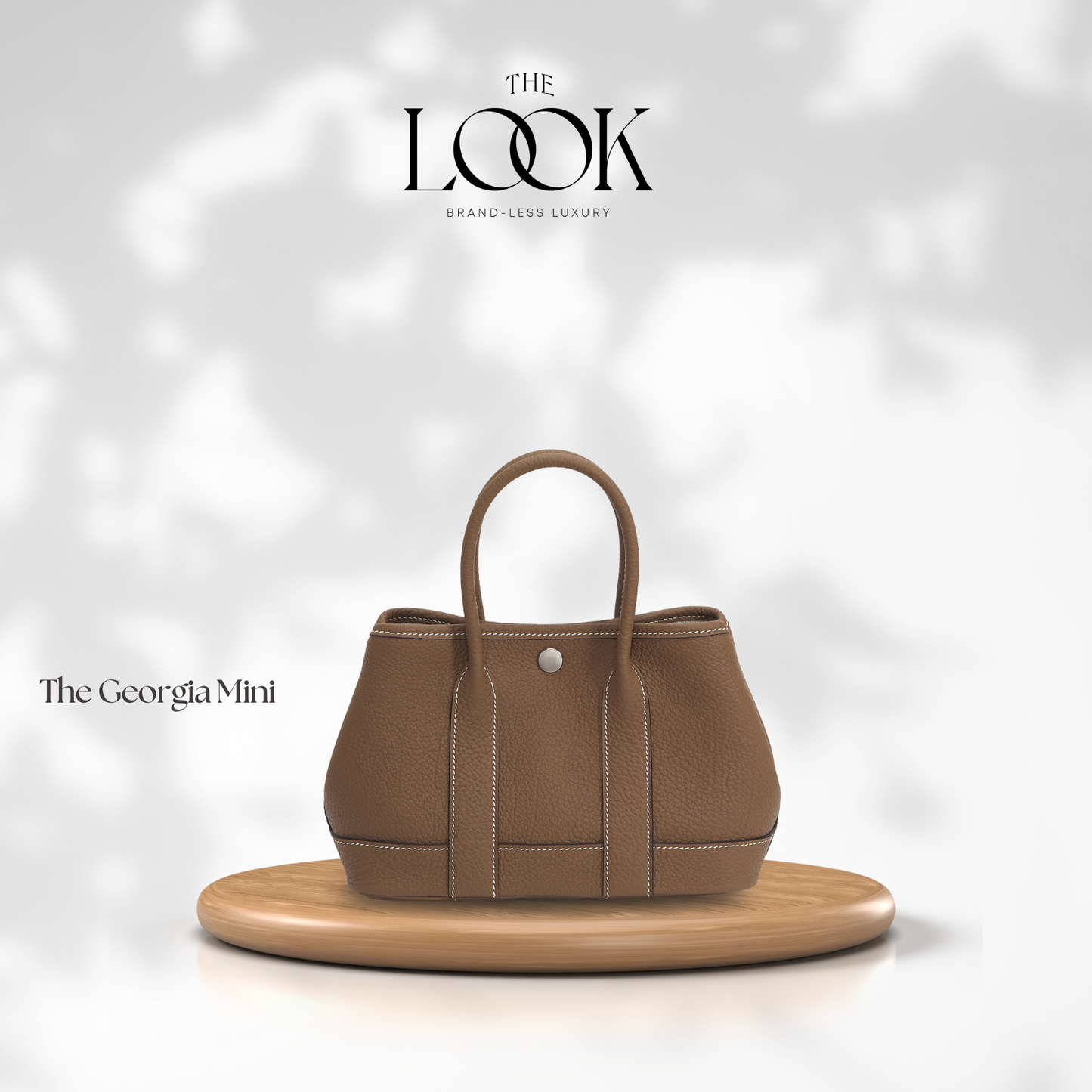Brown handbag on a wooden stand with 'The Look' branding on a light background | The Look Officiel