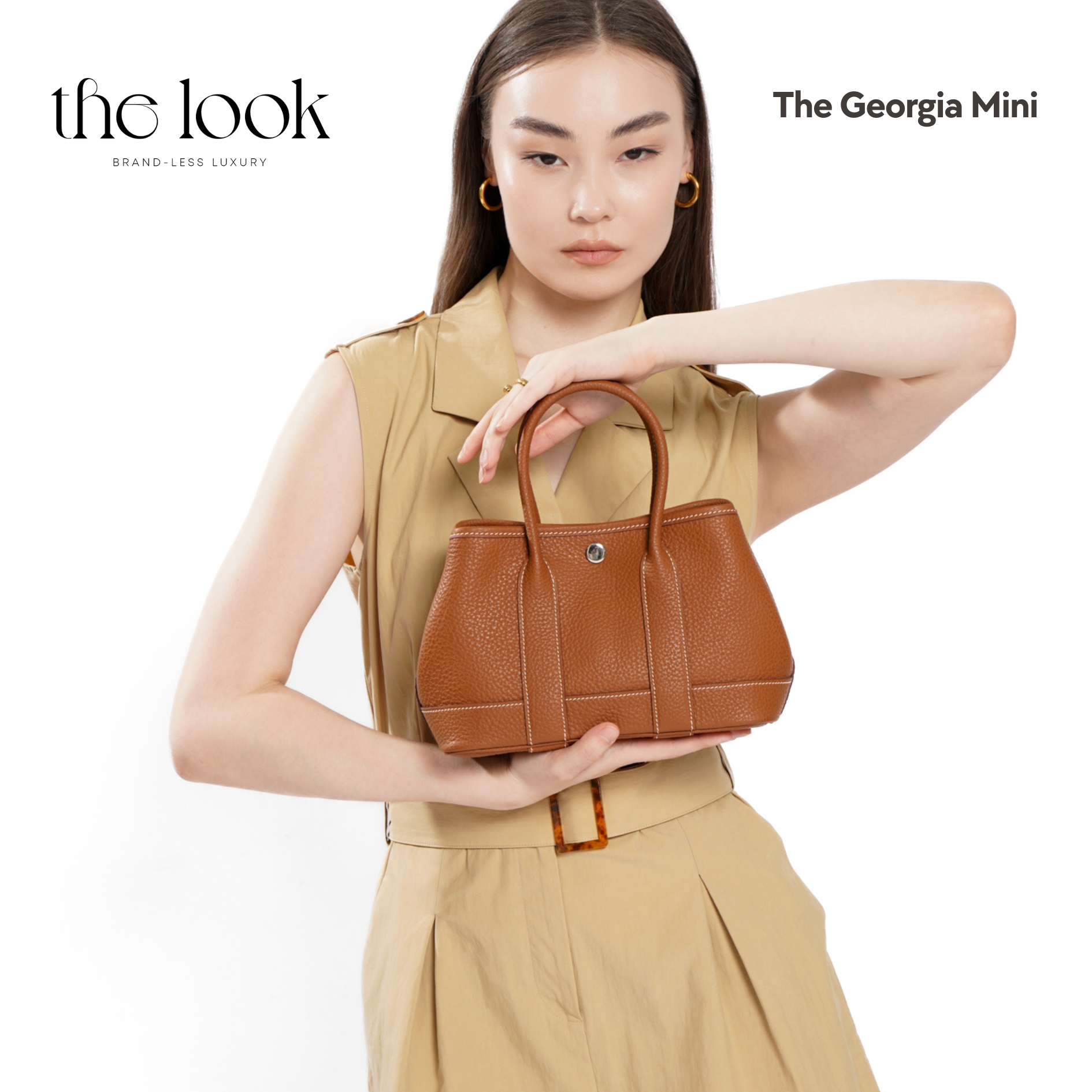 Woman holding a brown leather handbag with 'the look' branding on a white background | The Look Officiel