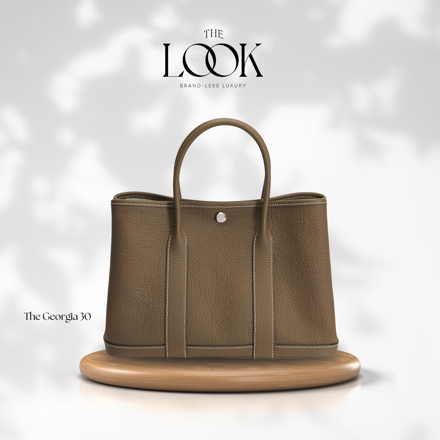 Brown handbag on a wooden stand with 'The Look' branding on a light gray background | The Look Officiel