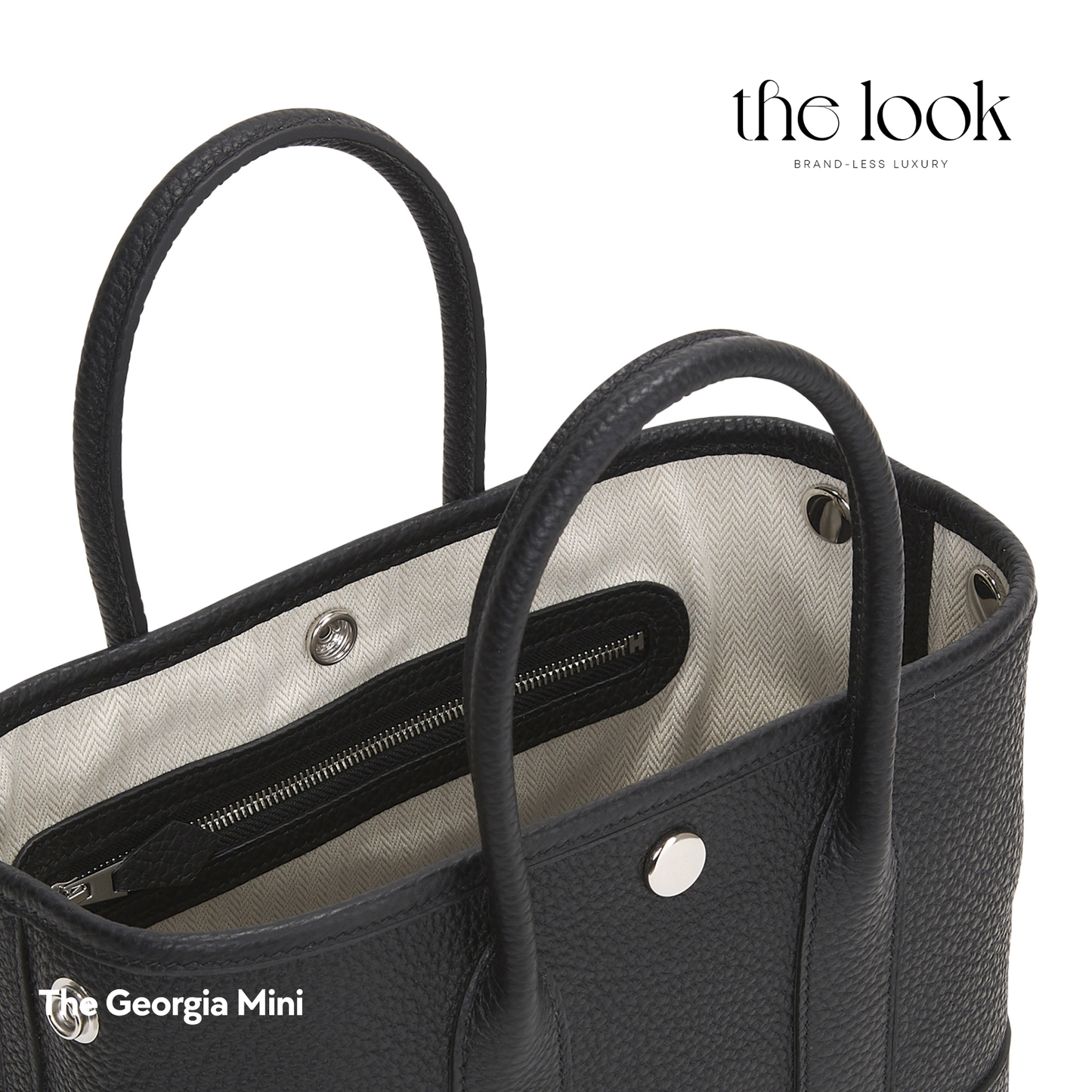 Black handbag with visible stitching and hardware on a white background, featuring 'the look' brand. | The Look Officiel