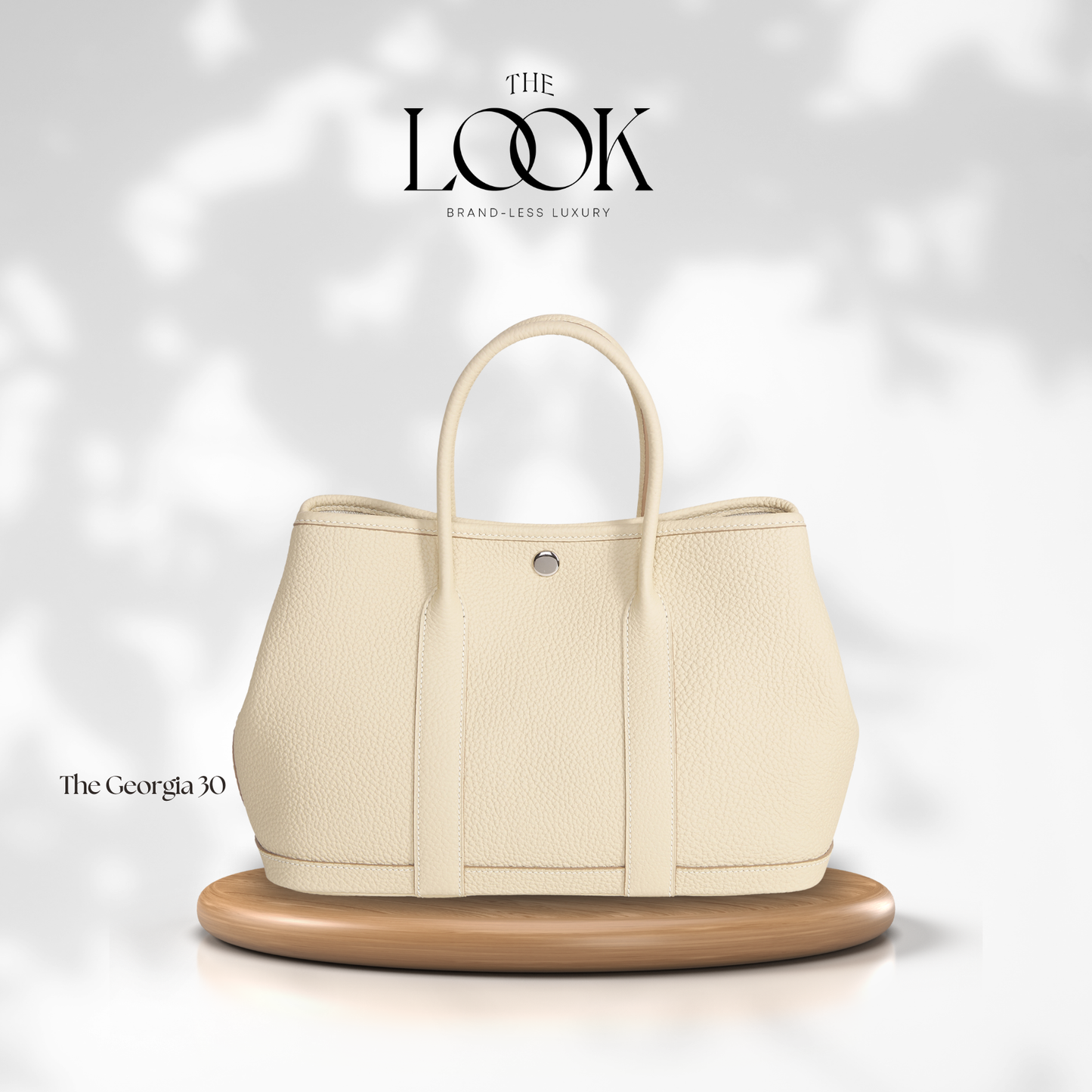 Beige handbag on a wooden stand with 'The Look' branding on a light gray background | The Look Officiel
