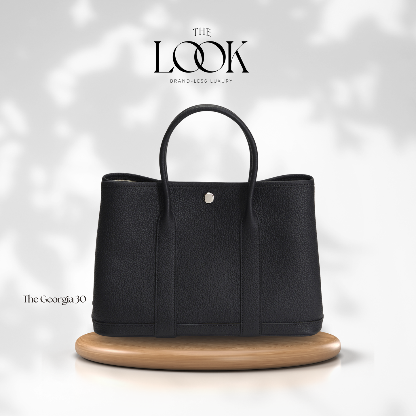 Black handbag on a wooden stand with 'The Look' branding on a light gray background | The Look Officiel