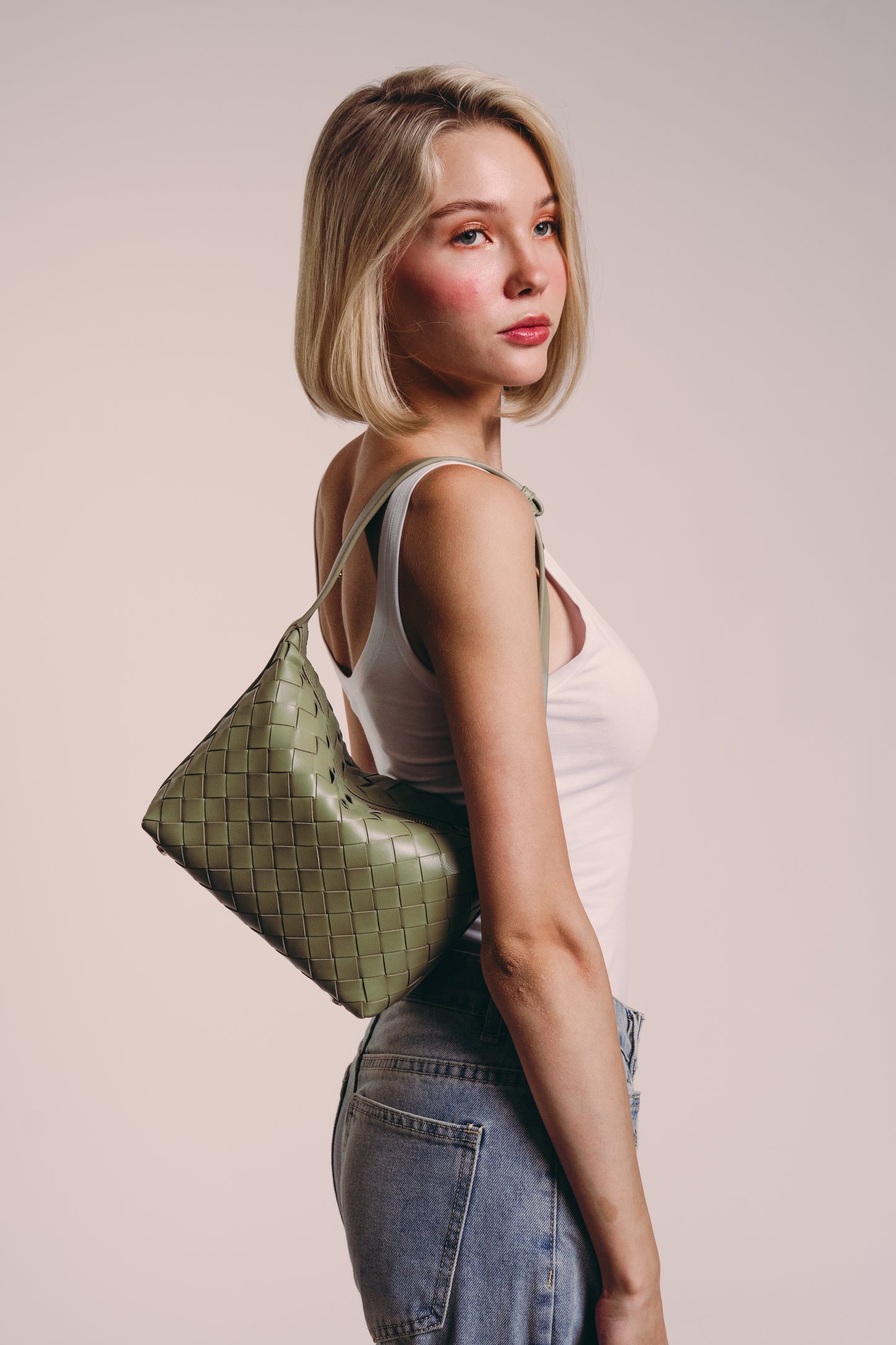 Girl wearing Loop Mini convertible shoulder bag travertine lambskin woven knotted strap gold-tone hardware on shoulder