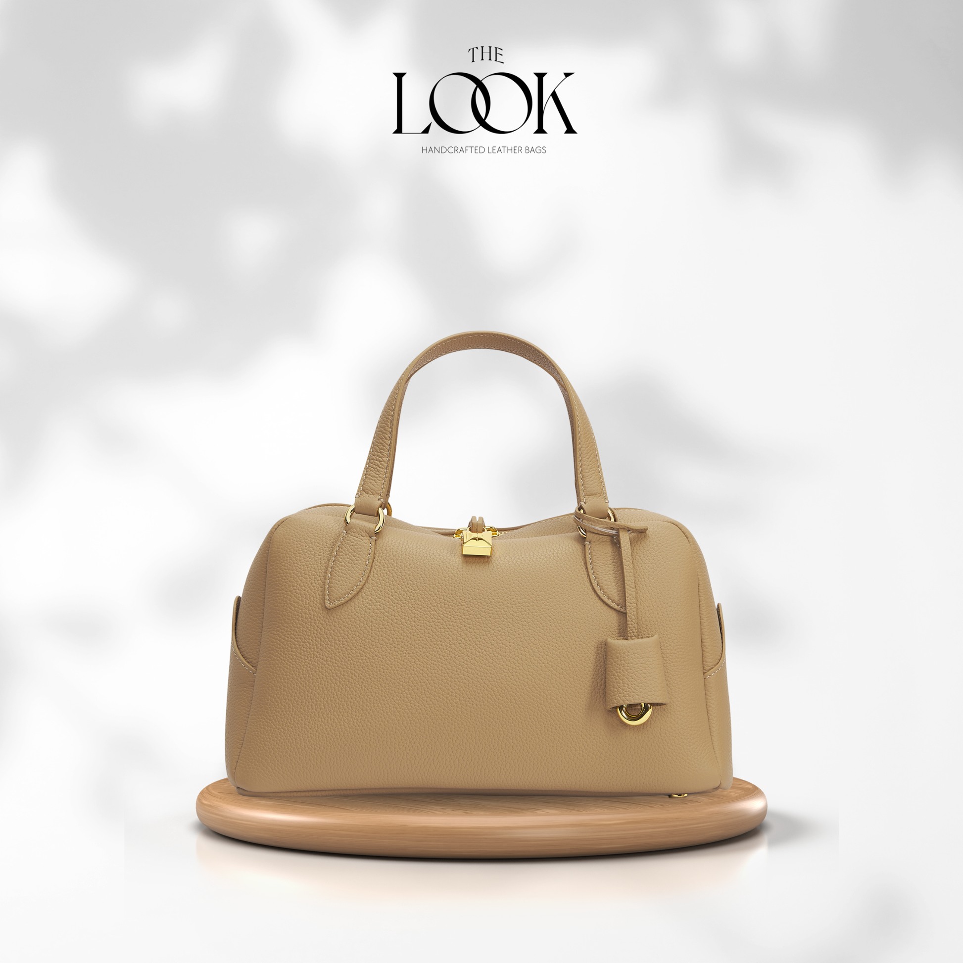 Beige handbag on a white platform with 'The Look' brand logo above. | The Look Officiel