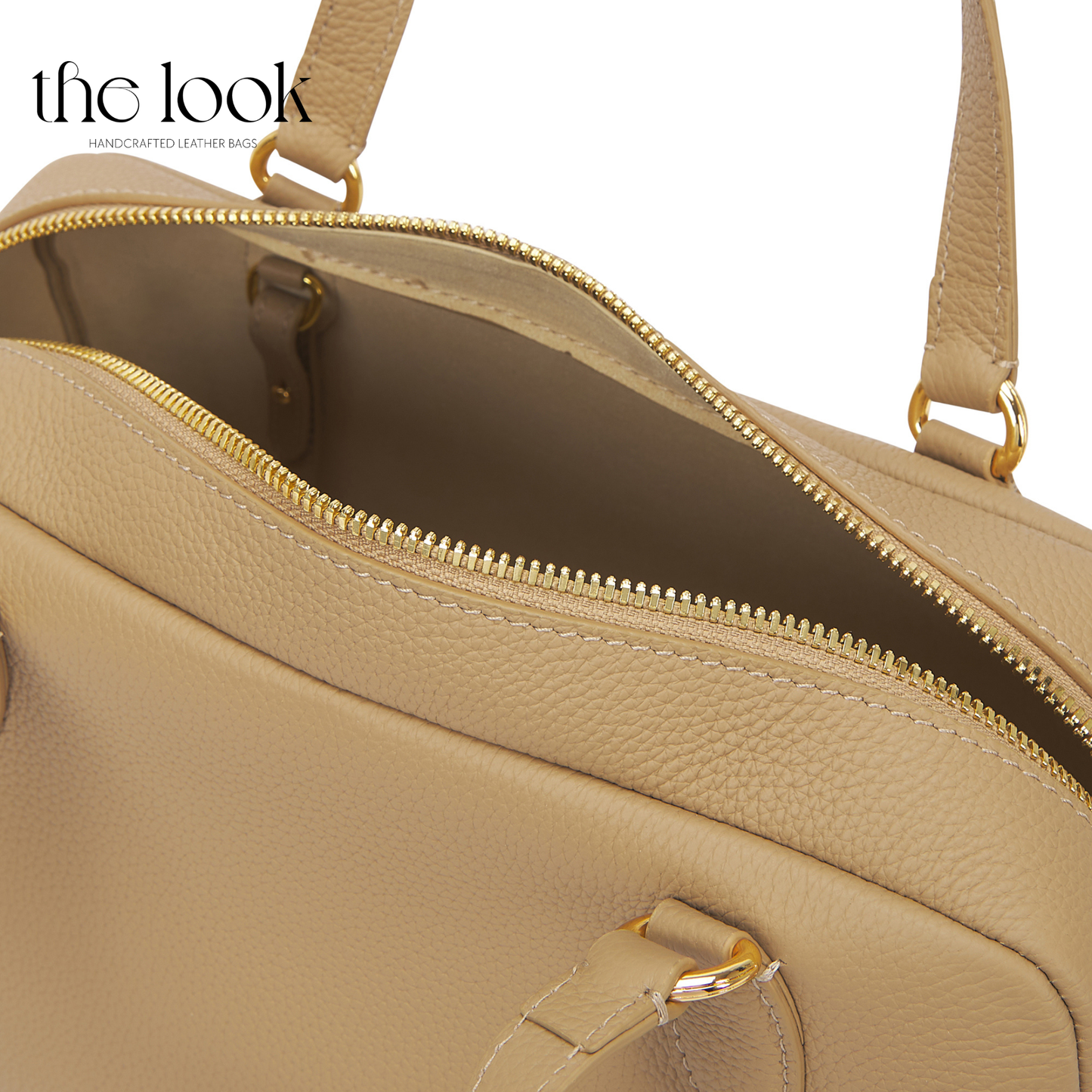 Beige handbag with gold zipper and hardware on a white background. | The Look Officiel