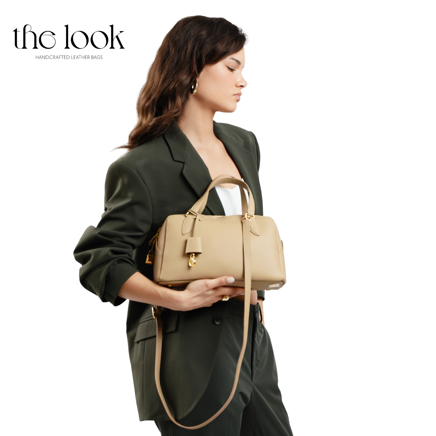 Woman holding a beige handbag with 'the look' branding on a white background. | The Look Officiel