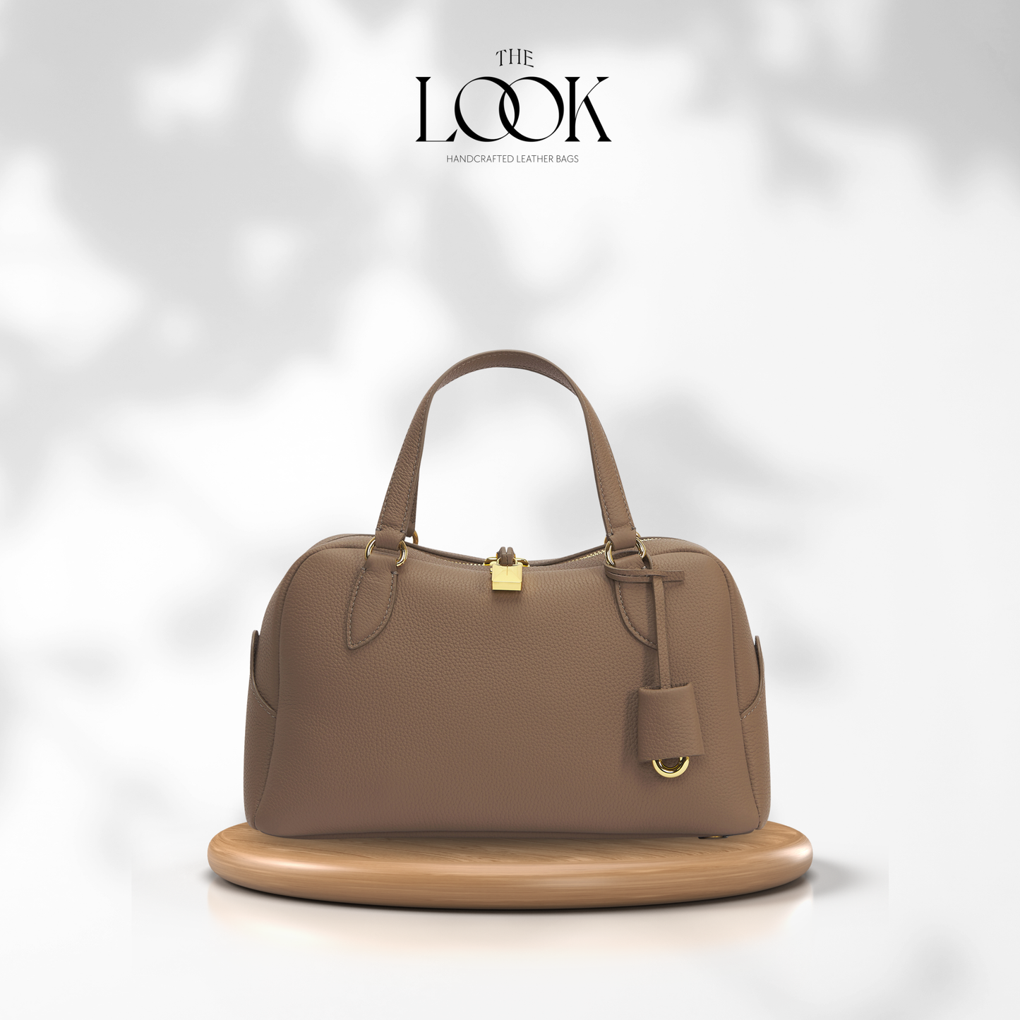 Brown leather handbag on a white platform with 'The Look' branding. | The Look Officiel