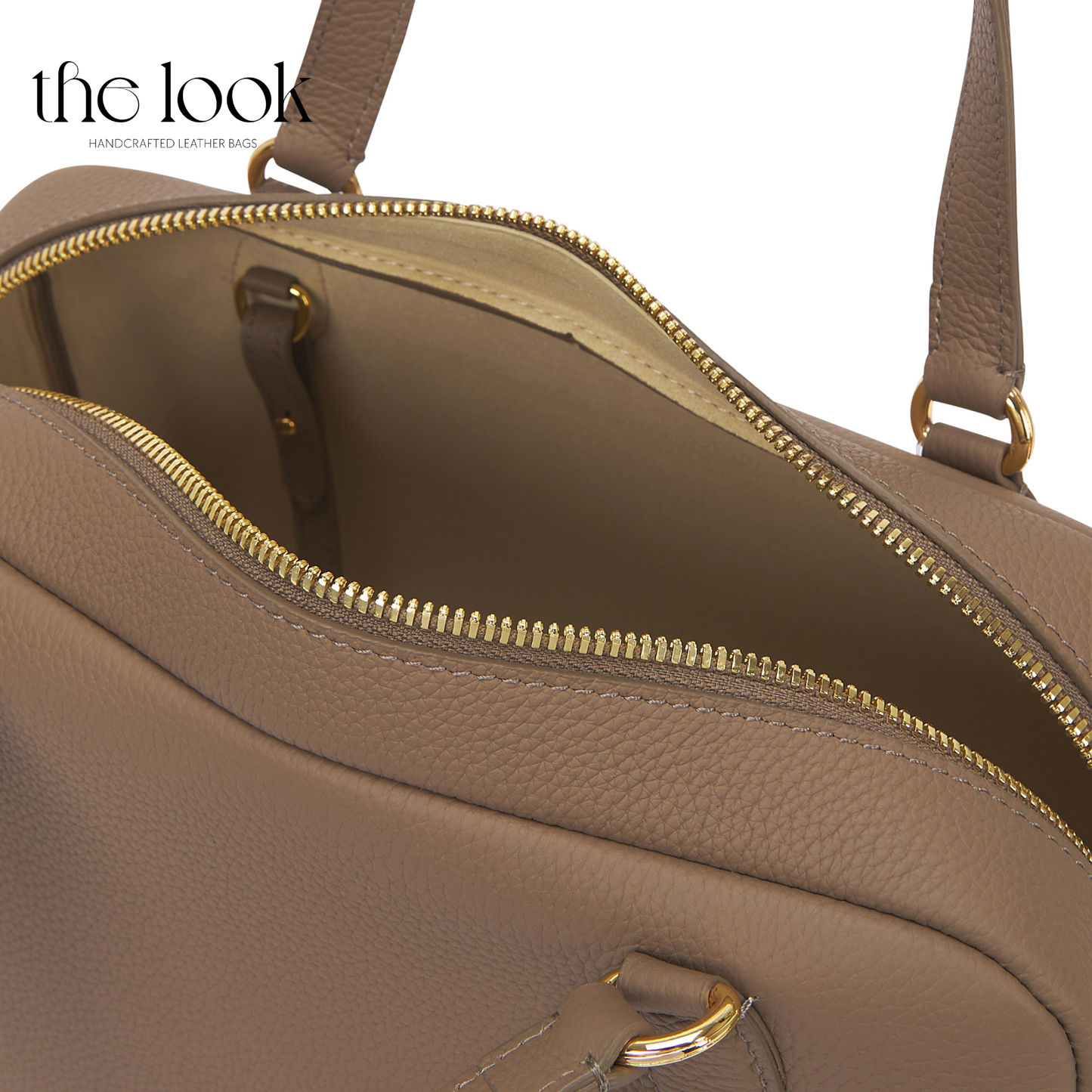 Close-up of a brown leather handbag with gold zipper and hardware. | The Look Officiel