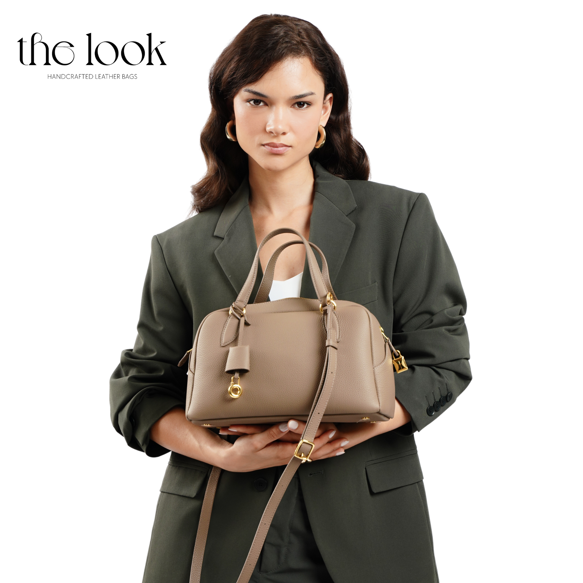 Woman holding a beige handbag with 'the look' branding on a white background. | The Look Officiel