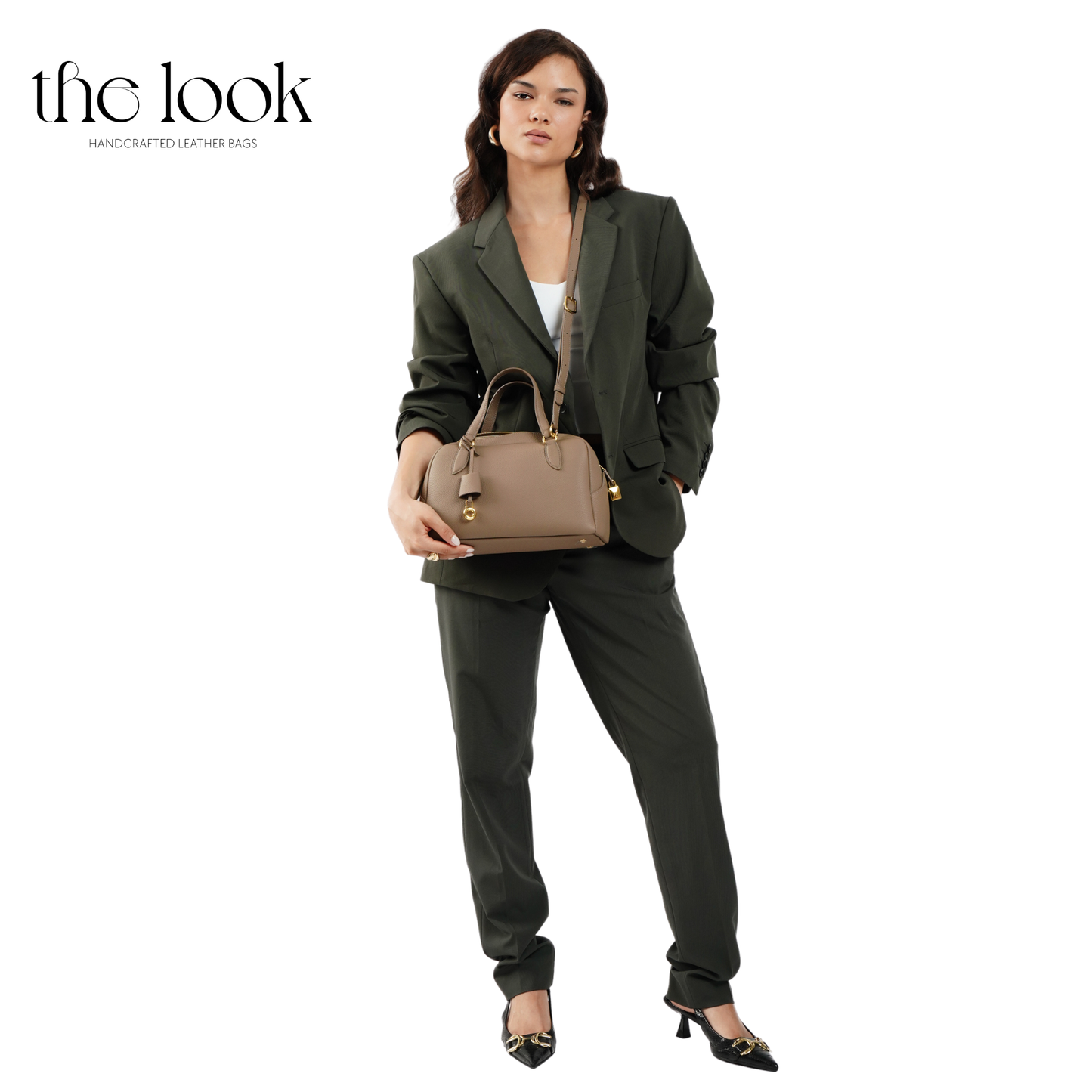 Woman in a green suit holding a brown handbag with 'the look' branding. | The Look Officiel