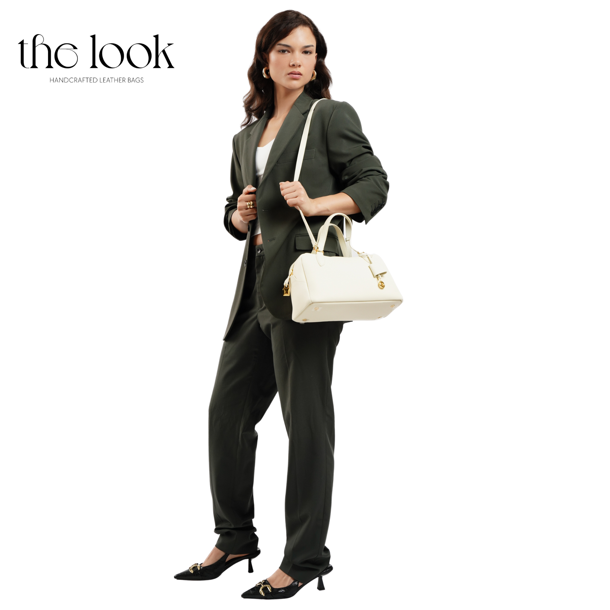 Woman in a green suit holding a white handbag with 'the look' branding. | The Look Officiel