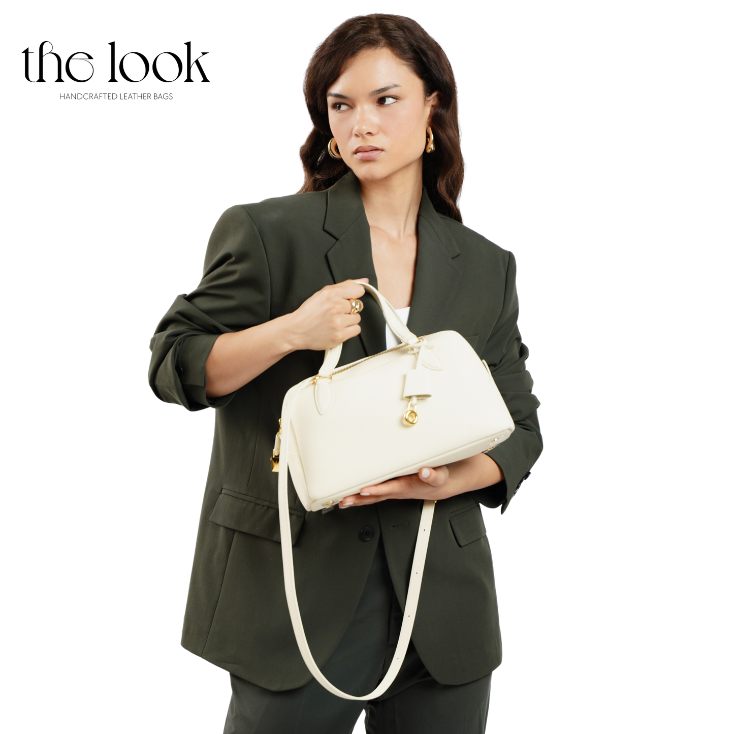 Woman holding a white handbag with 'the look' branding on a white background. | The Look Officiel