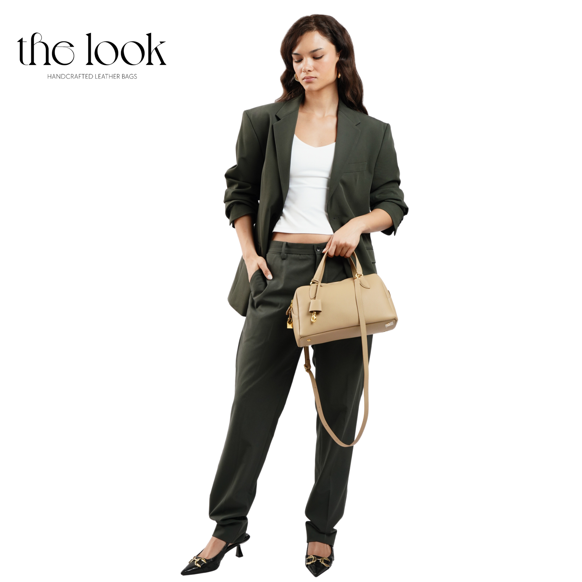 Woman holding a beige handbag with 'the look' branding on a white background. | The Look Officiel