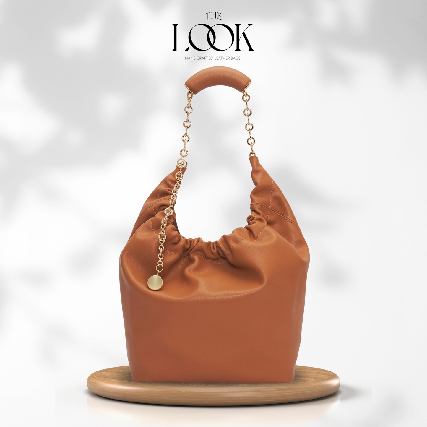 Brown handbag with gold chain handle on a white background, featuring 'The Look' magazine logo. | The Look Officiel