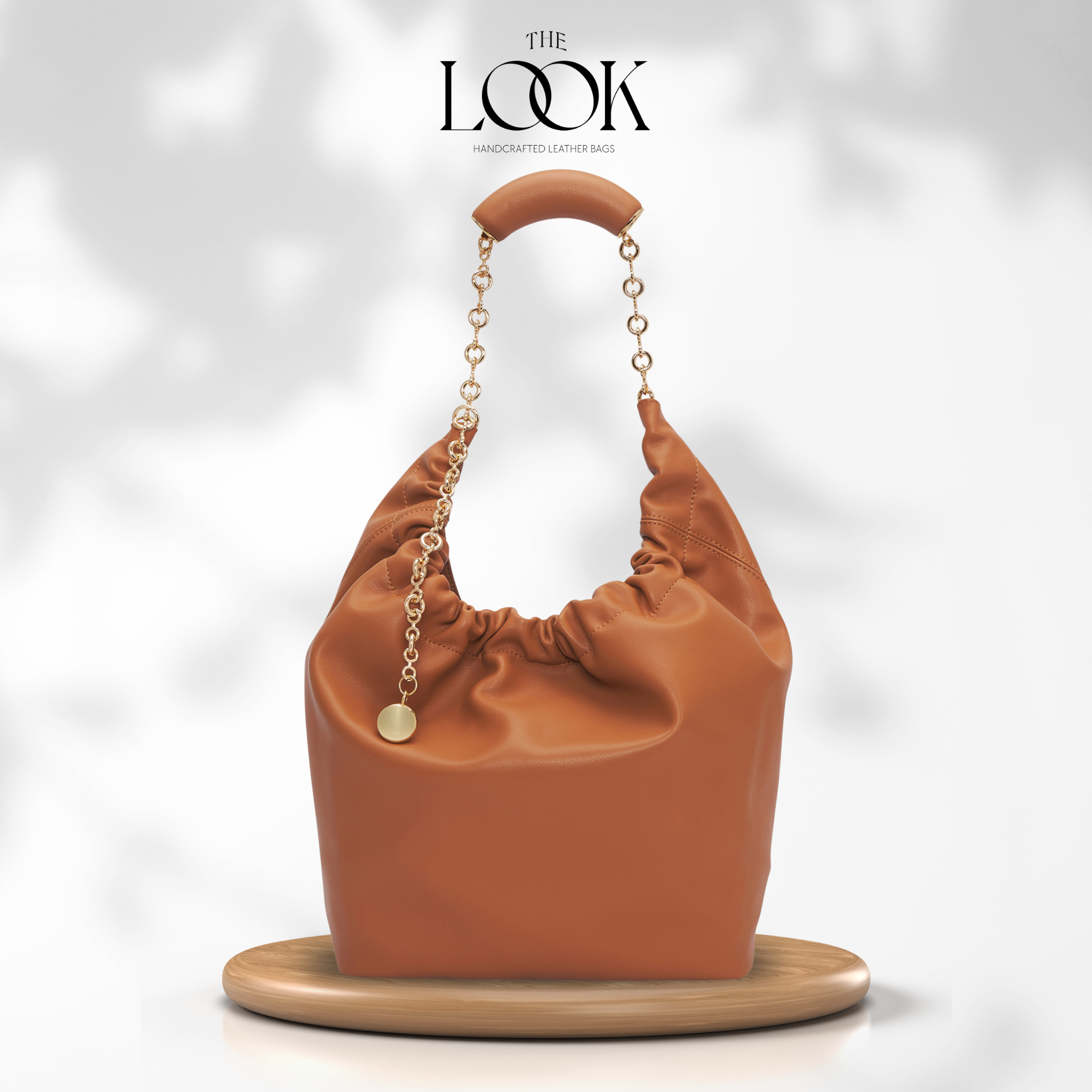 Brown handbag with gold chain handle on a white background, featuring 'The Look' magazine logo. | The Look Officiel