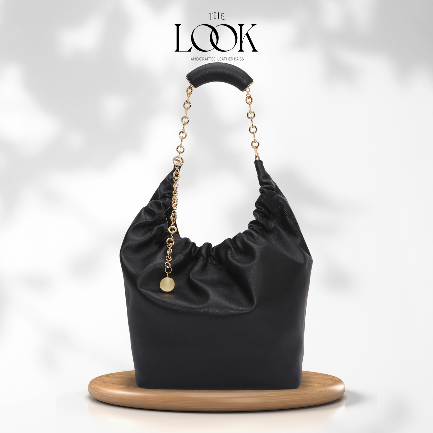 Black handbag with gold chain handle on a white background, branded 'The Look'. | The Look Officiel