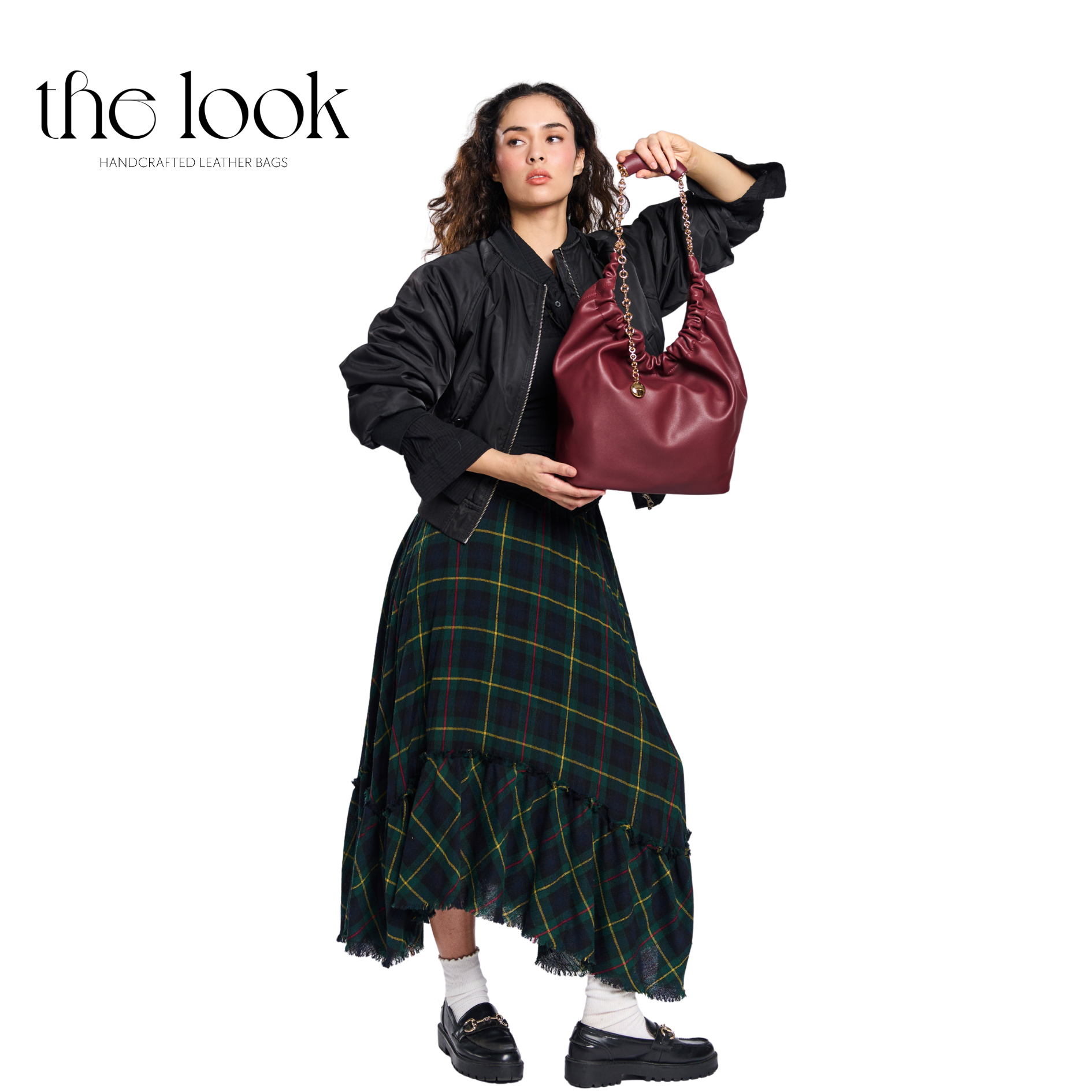 Woman holding a maroon handbag with 'the look' branding on a white background. | The Look Officiel