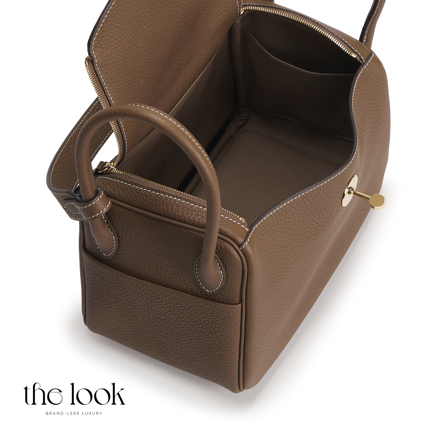 Brown leather handbag with gold zipper on a white background | The Look Officiel