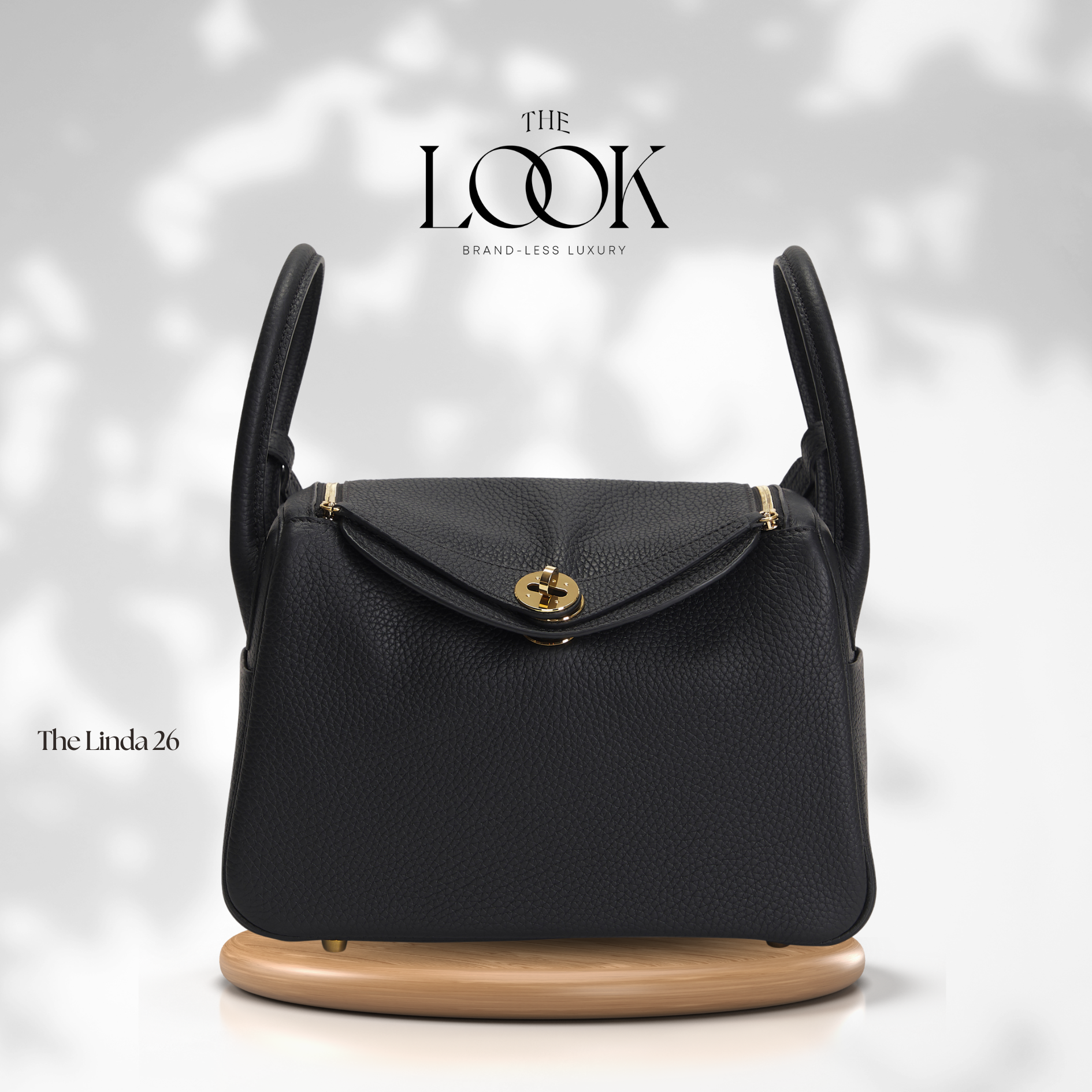 Black handbag with gold clasp on a white background, featuring 'The Look' brand. | The Look Officiel