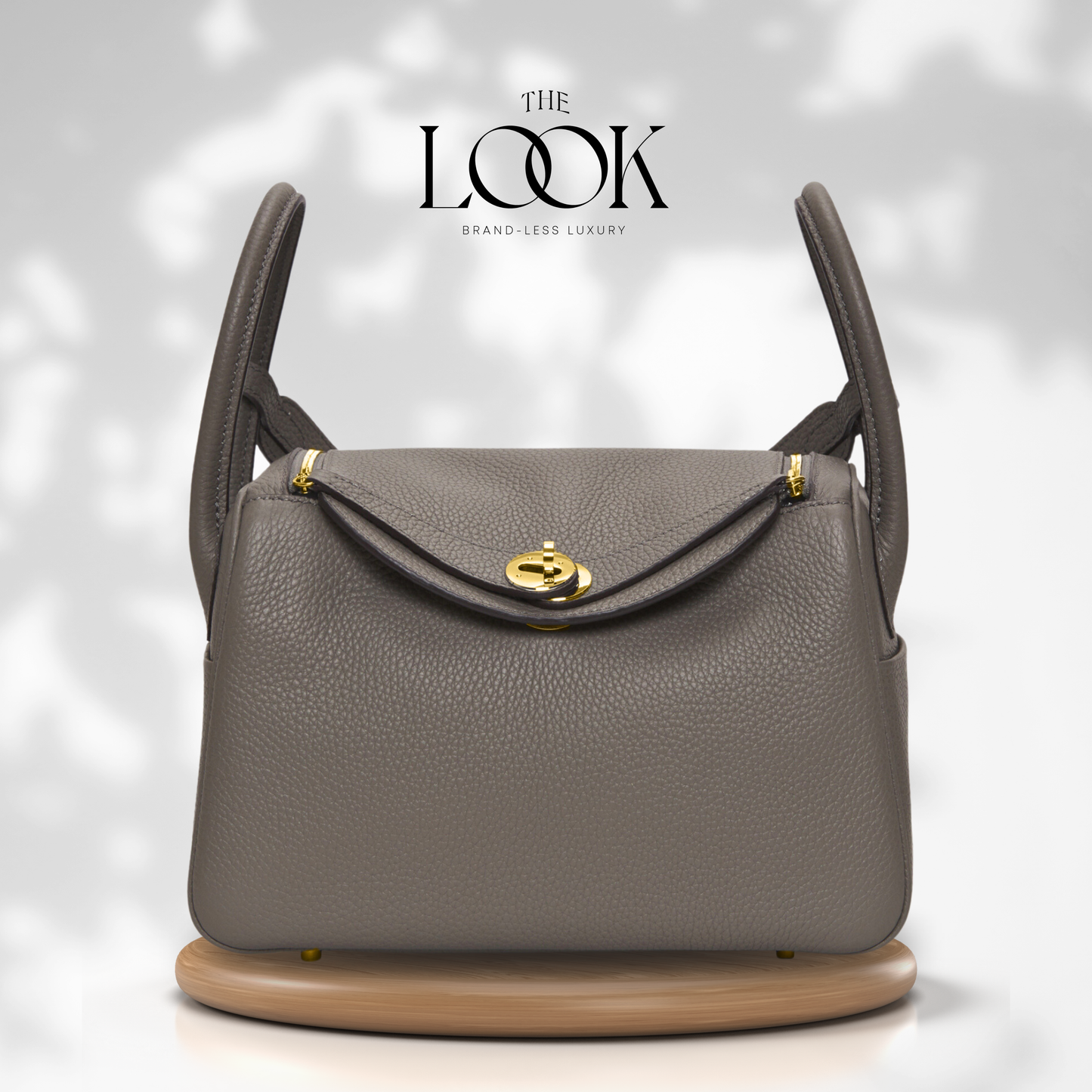 Gray handbag with gold accents on a white background, featuring 'The Look' brand. | The Look Officiel