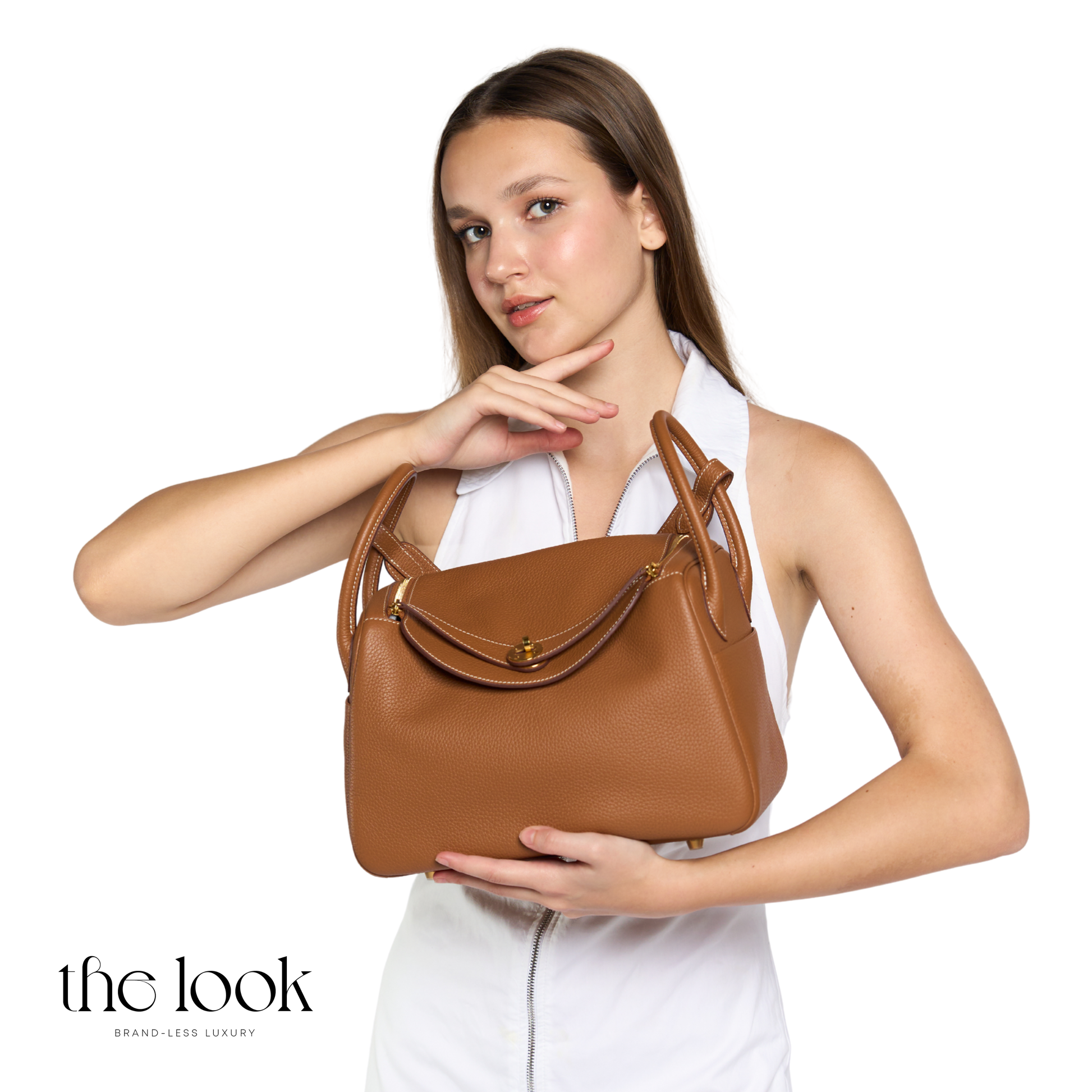 Woman holding a brown handbag against a white background | The Look Officiel