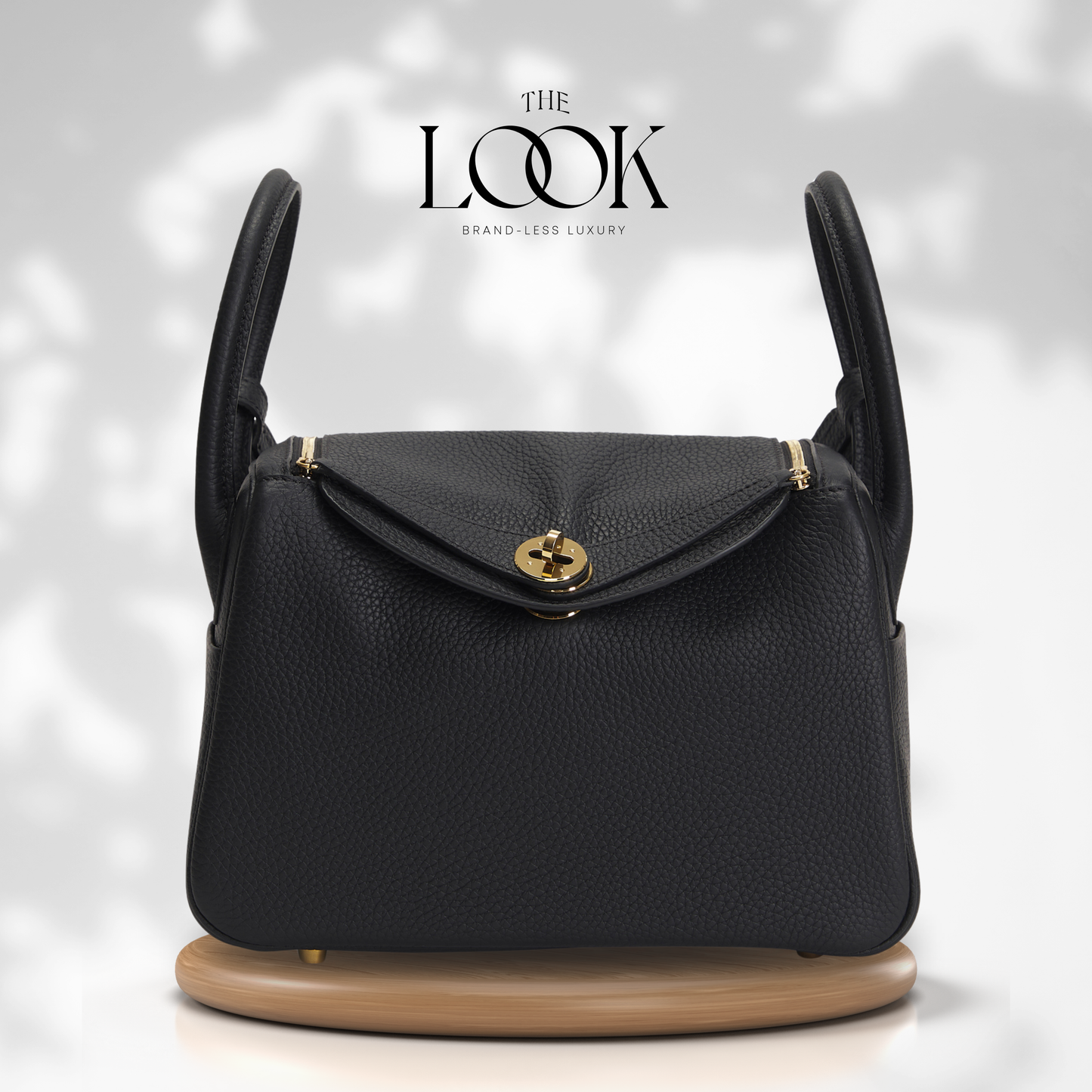 Black handbag with gold accents on a white background, featuring 'The Look' brand. | The Look Officiel