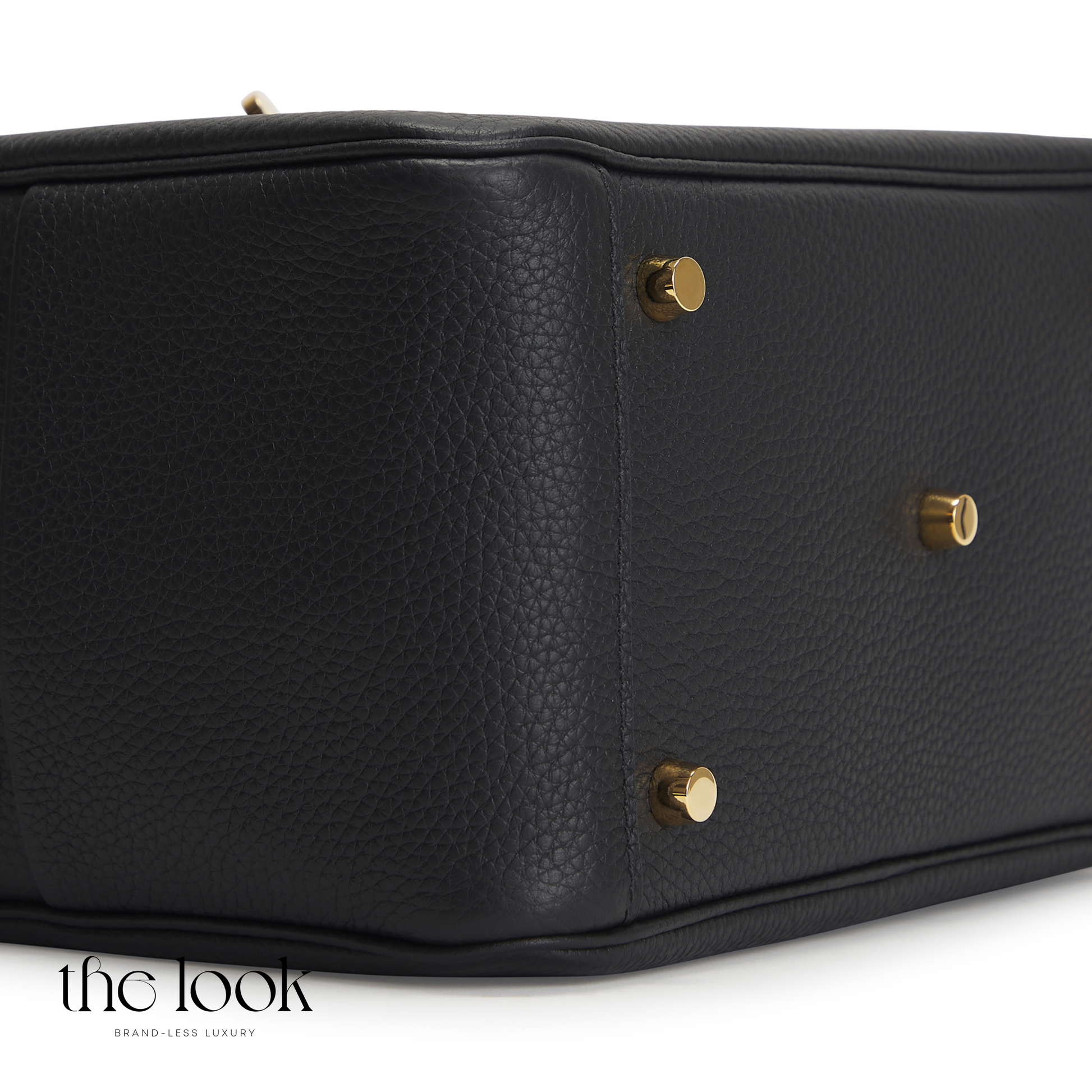 Black leather handbag with gold hardware on a white background, featuring 'the look' brand. | The Look Officiel