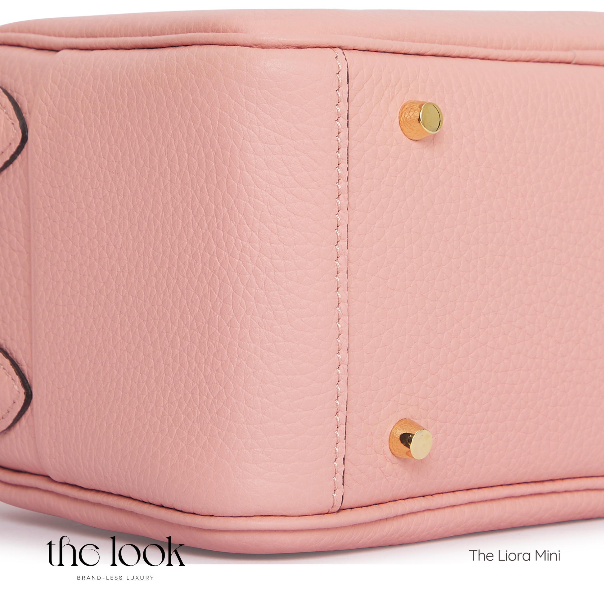 Close-up of a pink handbag with gold accents, featuring 'The Look' branding. | The Look Officiel
